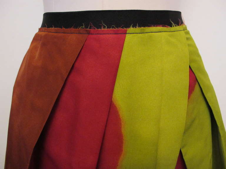 Marni multi-colored skirt with a unique form of pleating which captures a joyous blend of striking colors: chartreuse, royal blue, black, red, rust, navy blue in front of skirt. The reverse of the skirt is black with raw edges bordering at the top