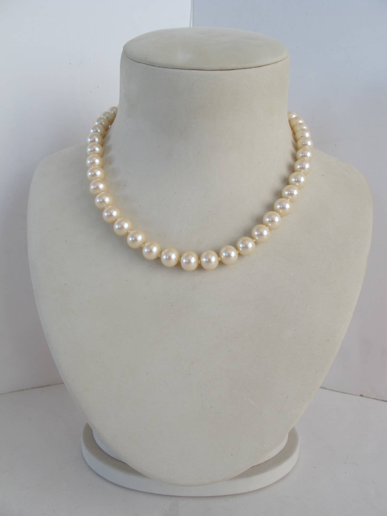 This 1.5 cm pearl necklace pearl necklace is hand - knotted. Because of its simplicity and rhinestone disco ball closure, it will adorn the neck with elegance.