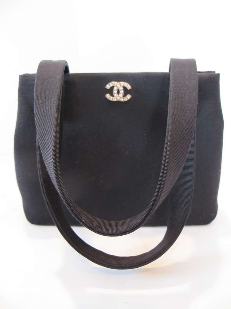 Elegant black silk faille evening handbag originally purchased at Chanel Boutique, San Francisco. Chanel Carte D'Authenticite enclosed numbered 5833533.