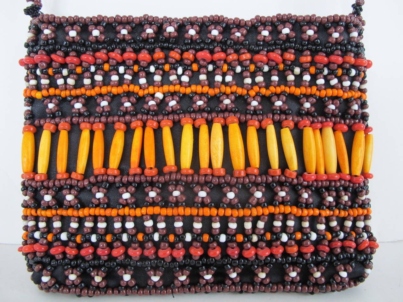 This African purse is created from African wooden and glass beads. It was donated to Helpers by San Francisco's iconic store: Wilkes Bashford. Original price of handbag was $865.00. The beads are hand sewn to bag.