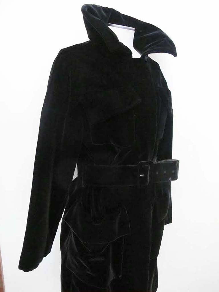 Tom Ford's Black Velvet Trench Coat with cinched belt has his signature style. The silhouette is recognizably Ford with sharp tailoring and pristine details. Belt measures 30 to 35 inches length and 2.5 inches wide. Shoulder to shoulder measures 27