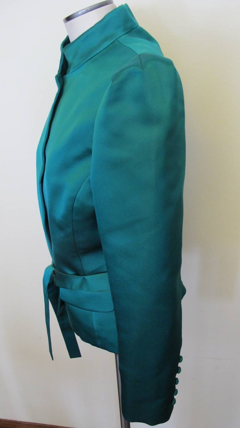 Prestine Emerald Green Silk Satin Jacket to be worn for evening events. The Mandarin collar and silk tie below the waist compliments the over all elegance of this divine jacket. There are 5 covered green silk satin buttons on each sleeve. Sleeve