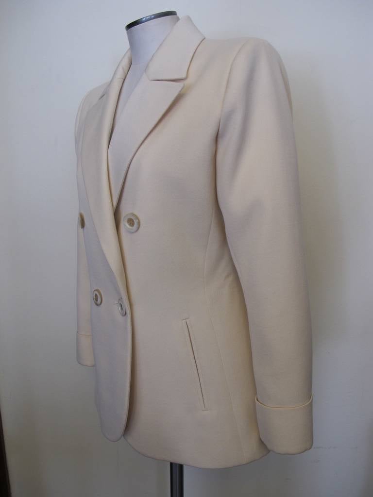 Classic Iconic elegant Yves St. Laurent  ivory double breasted jacket. The fabric is wool gabardine. The lines of the jacket represent the artistry and genius of Yves St. Laurent the master. Sleeve Length Measures 23 inches. Shoulder to shoulder