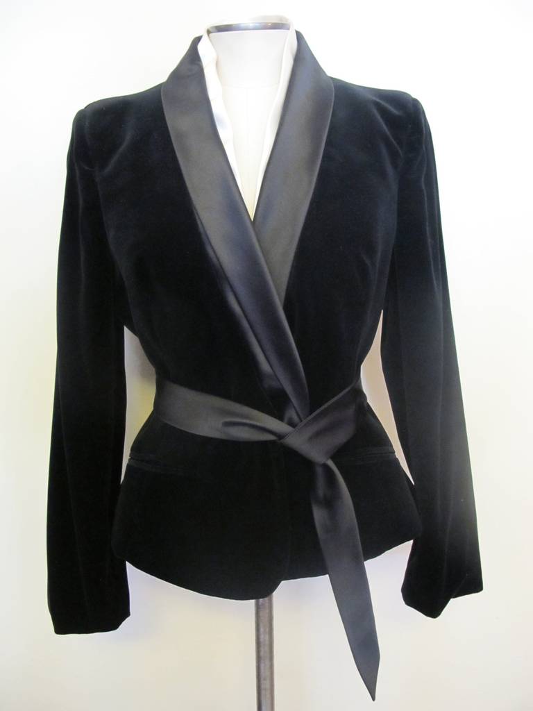 This piece was created when Alexander McQueen was in his prime. The black velvet tuxedo jacket has a double collar which is attached with white satin and black satin. It is a take off on the elegant smoking jacket. Black Satin belt is attached to