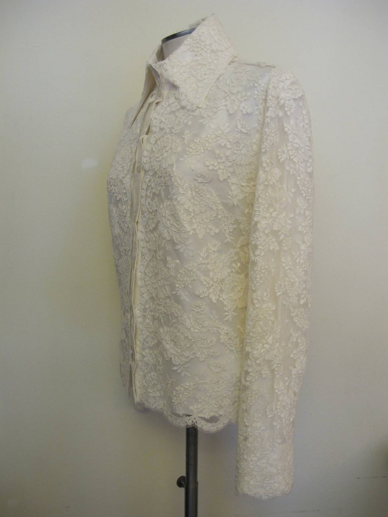 New Valentino Alençon lace blouse lined in white silk satin with scallops surrounding the sleeves, collar and bottom of blouse. Sleeve length measures 25.5 inches. Shoulder to shoulder measures 15.5 inches.