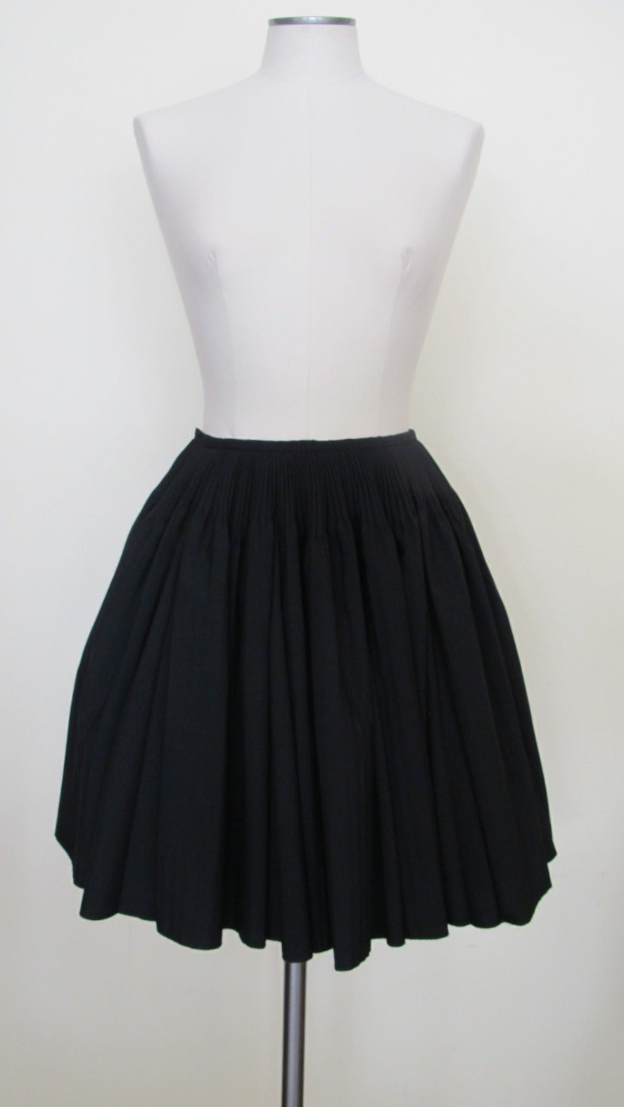 Exquisite fine black wool Alaia skirt with 3.5 inch plisse design below waist band. The skirt is lined in a heavy taffeta like polyester which gives a strong body to the design of the charming and chic skirt linking. The Taffeta Polyester lining is