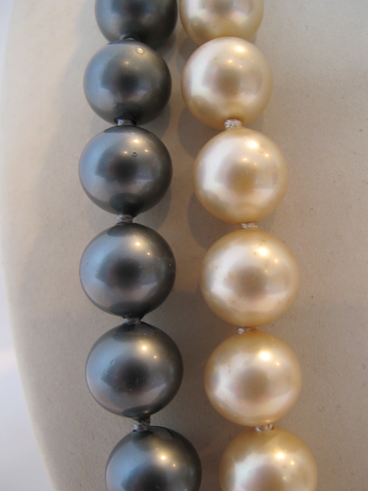 Fabulous K.J.L. (Kenneth Jay Lane) double strand imitation black and cream South Sea Pearl necklace. The cream necklace is 25 inches including closure. the black necklace is 28 inches including closure. 41 cream pearls and 45 black pearls. The