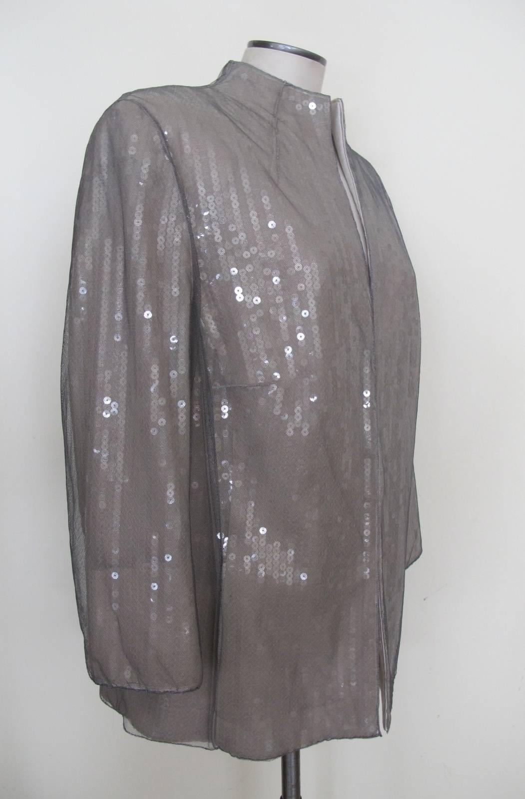 Clear Sequins is the design on ivory silk with exquisite grey netting serving as an overlay covering the sequins. The piece is sheer elegance. The sleeves are 3/4 length. Albert Kriemler, the creative director for Akris, is a genius and is known for