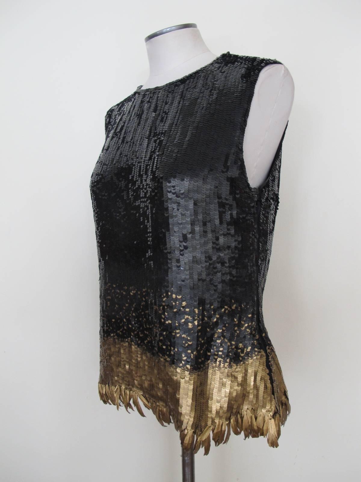 Elegant black sequin cocktail blouse from the waist down there are a mix of gold sequins cascading into three and a half inch panel of solid gold sequins. It is lined with black silk chiffon. The trim at the bottom are feathers that have been dipped