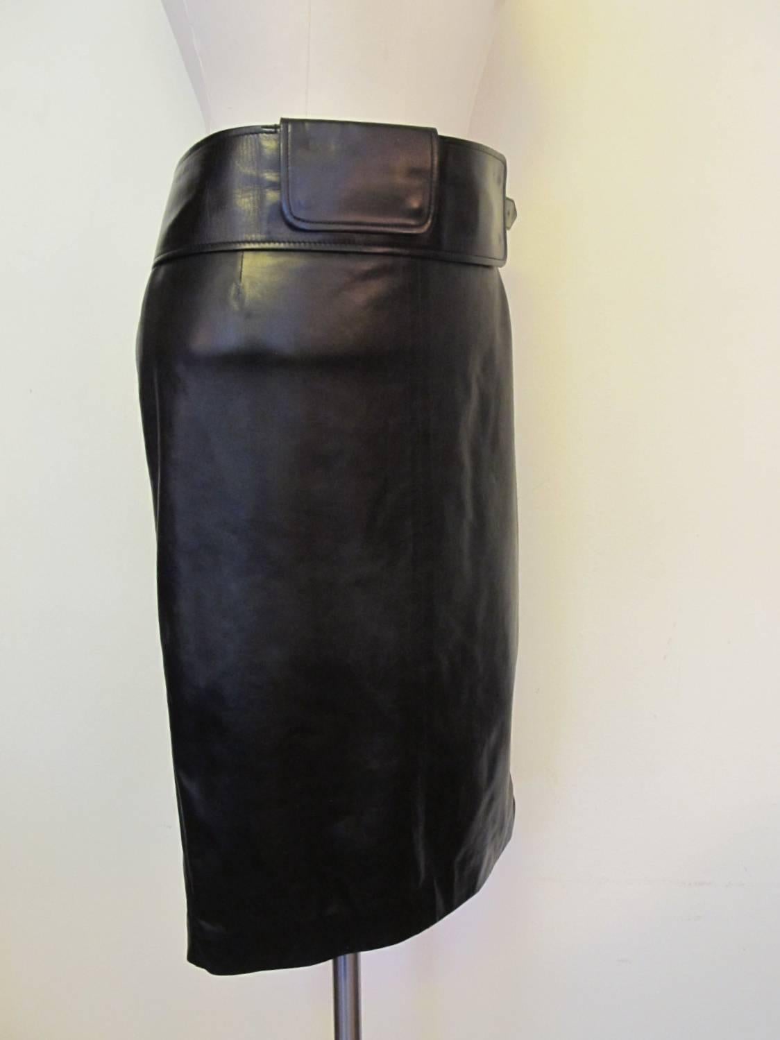 Chic soft black leather skirt created by Tom Ford for Yves St. Laurent. There is a 6 inch slit in the back of this luscious skirt. The black leather belt accompanies the skirt and has a pocket that snaps in front of the belt. The piece with belt is
