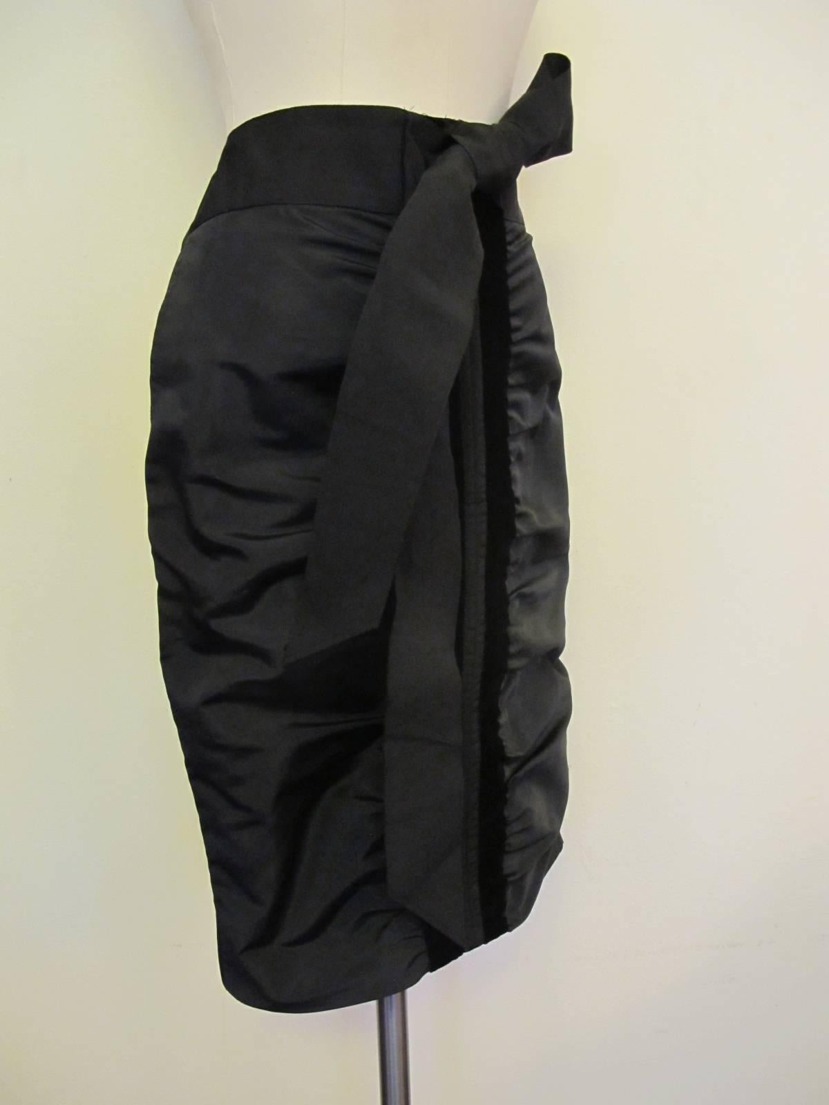 Chic Black taffeta skirt with gathered design trimmed in 1 1/16 inch velvet. The 2.5 inch gros grain belt is 29 inches long. There are two parts of the belt - totaling 58 inches - attached to the waist. There are two pockets. The front of the skirt