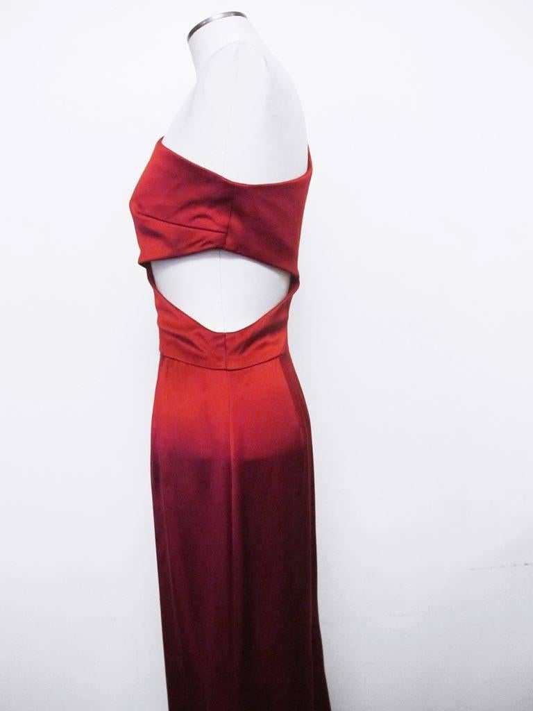 Exquisite red evening gown which contours the body with perfection. The one-shoulder gown has a cut out on the left side of the bodice. There are two pleats in front and in back of gown. There is a 32 inch slit on the right side of the shirt of the