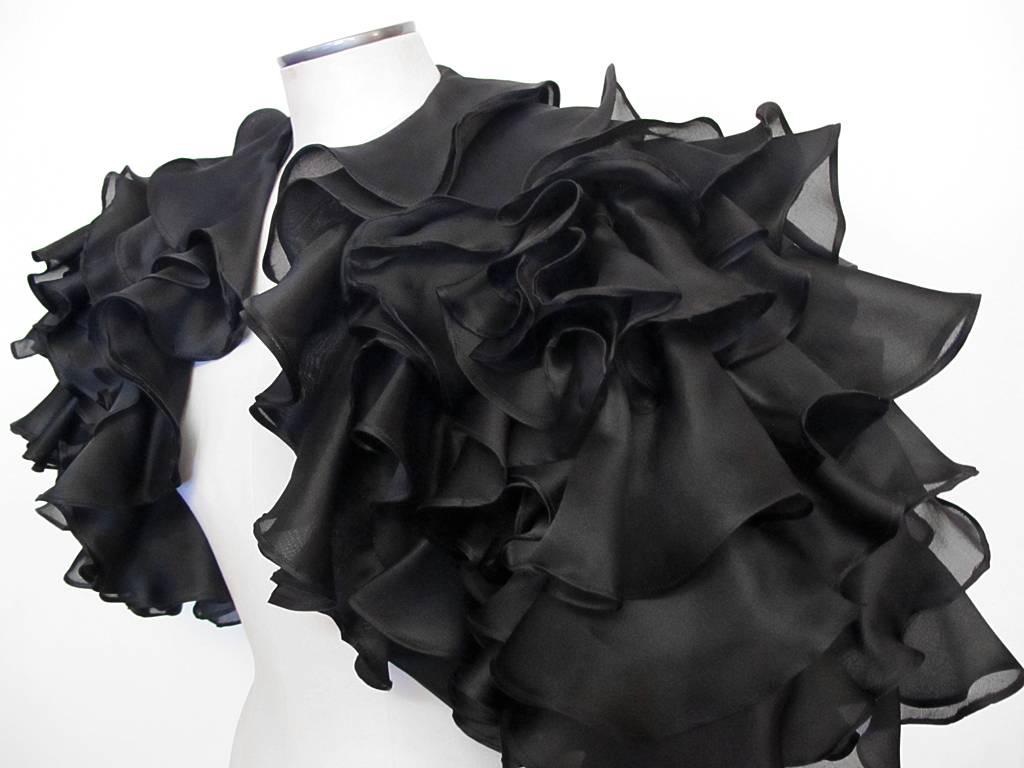 This stunning 1980's Victor Costa black organza bolero evening jacket will make any evening dress pop. It is completely covered in beautiful 100% silk organza ruffles. It is in excellent condition and fits a wide range of sizes. The bolero is marked