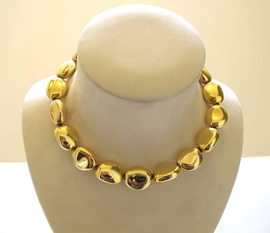This chic Ralph Lauren choker necklace is made up of pebble shaped beads in a heavy shiny metallic gold-tone. It is 18 inches long and the beads are 1 inch in diameter. 

YOUR PURCHASE BENEFITS THOSE WHO ARE DEVELOPMENTALLY DISABLED.