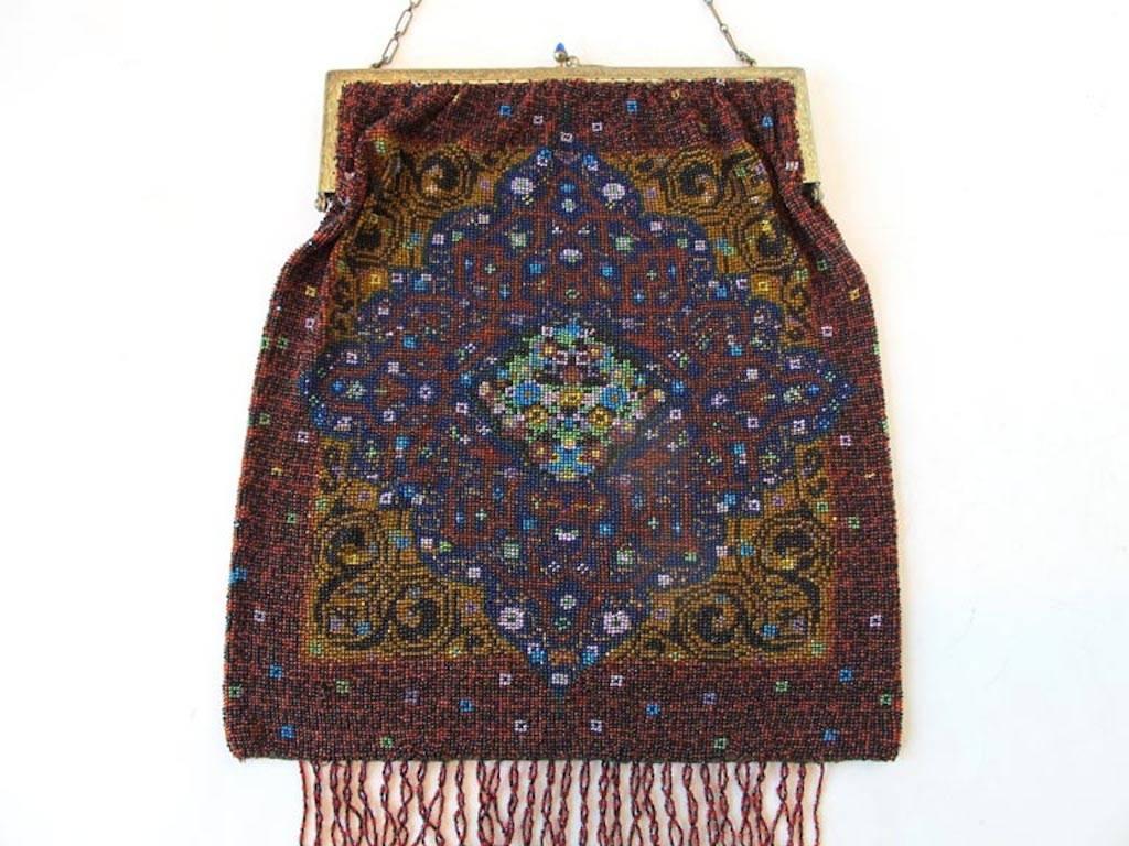 Intricately detailed antique glass seed beaded purse. Brass metal frame with chain handle. Beaded fringe at bottom. Unlined.

YOUR PURCHASE BENEFITS THOSE WHO ARE DEVELOPMENTALLY DISABLED.