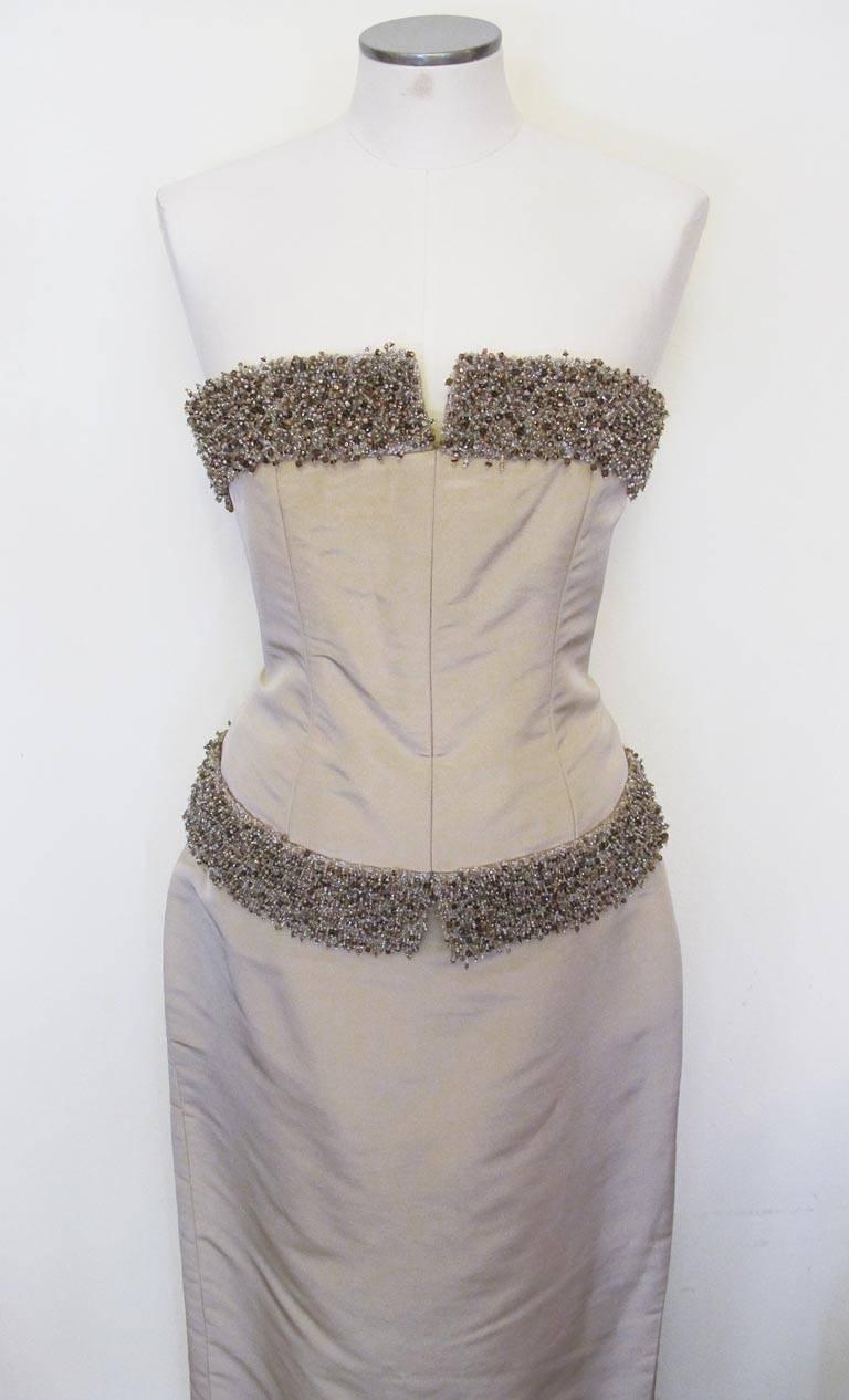 Exquisite Donald Deal taupe strapless two-piece gown in a silk faille taffeta. The bodice is boned and bordered in a three-dimensional glass seed beaded trim. The skirt is a column with fish-tail in back.

YOUR PURCHASE BENEFITS THOSE WHO ARE