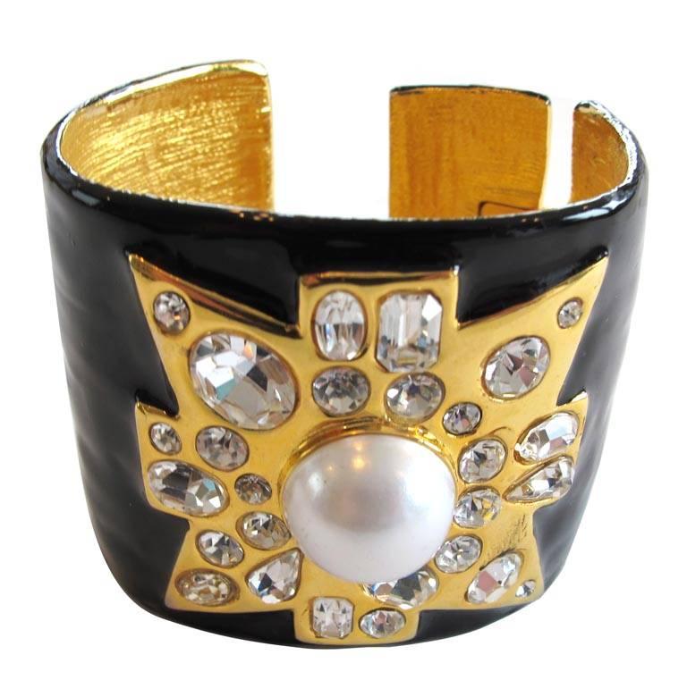 Kenneth Jay Lane Maltese cross cuff bracelet in black enamel and gold-tone with rhinestone and a faux pearl. Spring opening for easy on and off. Signed.

YOUR PURCHASE BENEFITS THOSE WHO ARE DEVELOPMENTALLY DISABLED.