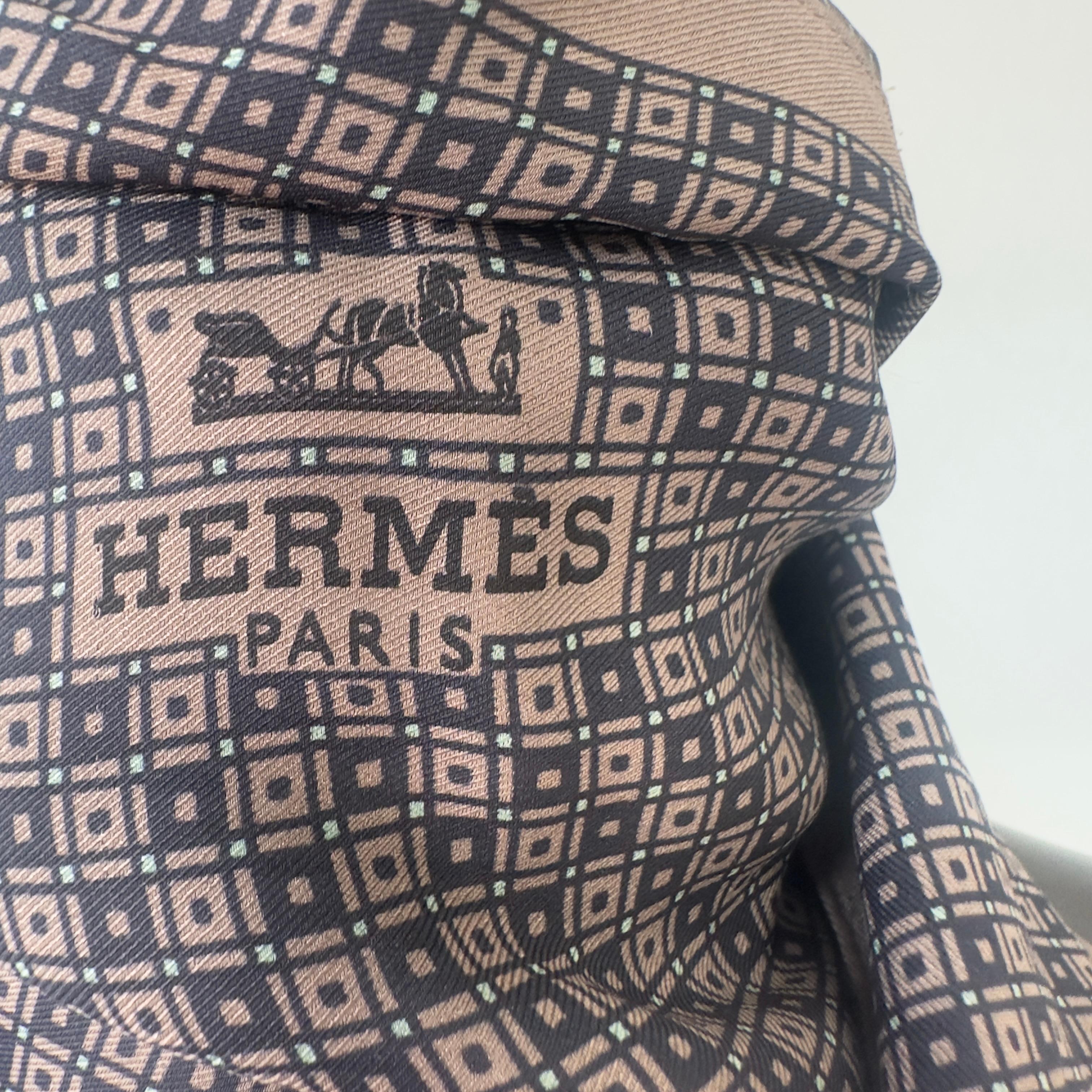 Sciarpa Hermès in seta – Beige rosato e blu scuro
Un mix raffinato di tonalità polverose caratterizza questa sciarpa Hermès in seta, decorata con pattern grafico su base blu scuro e bordi in beige rosato. Firmata Hermès Paris, è perfetta per chi ama