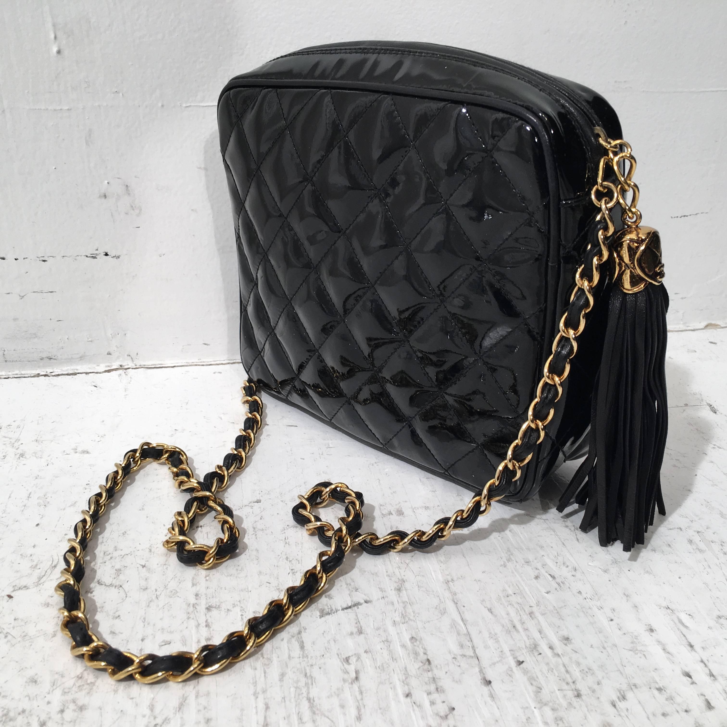 Chanel 1980's vintage quilted patent leather crossbody bag features a diagonal front exterior, flat pocket, the Chanel logo stitched at front, and a zip closure with a leather tassel pull. Gold chain shoulder strap, original box and serial number