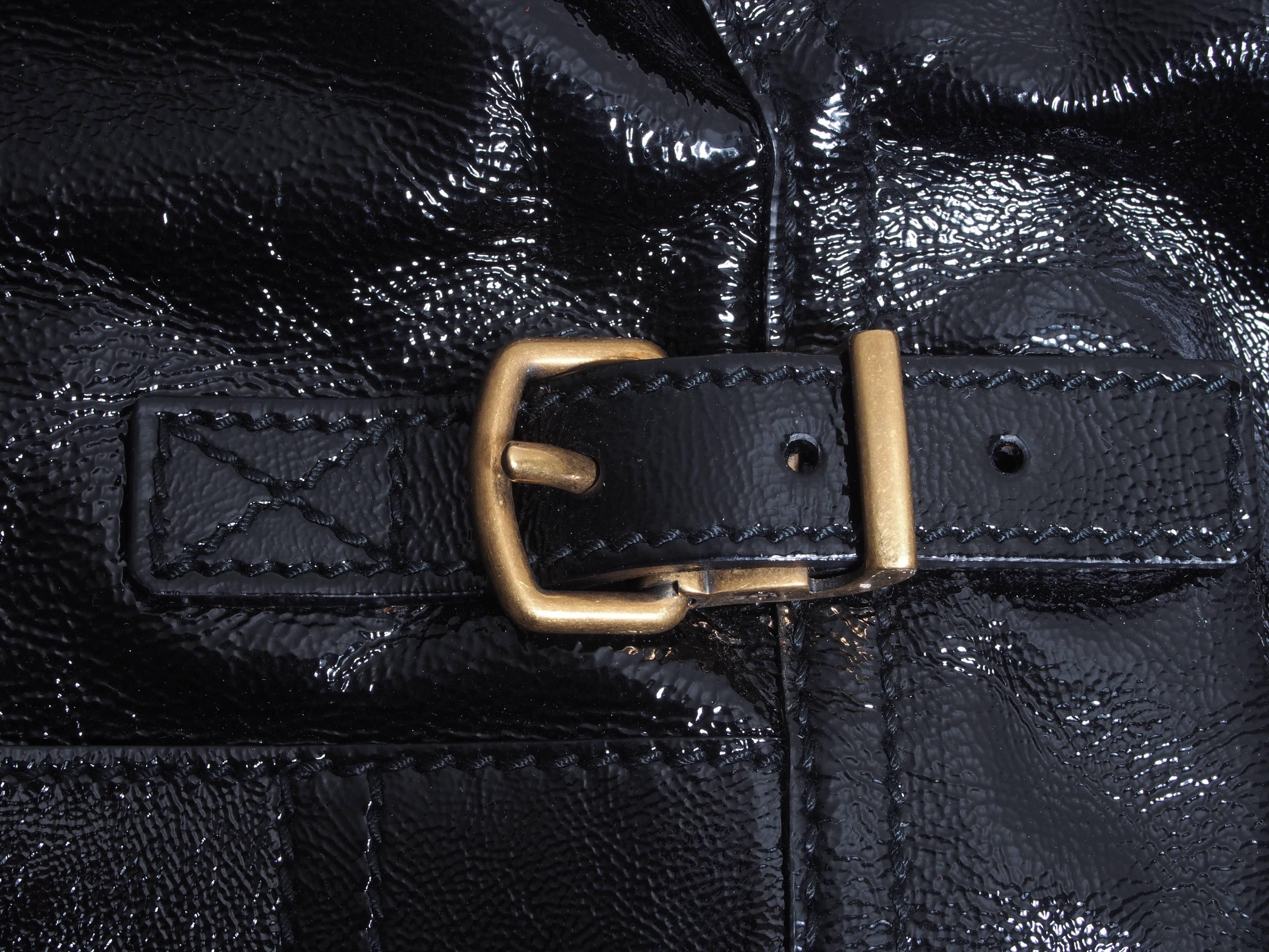 Iconic oversized patent leather tote featuring gold zipper and snap hardware detailing 
