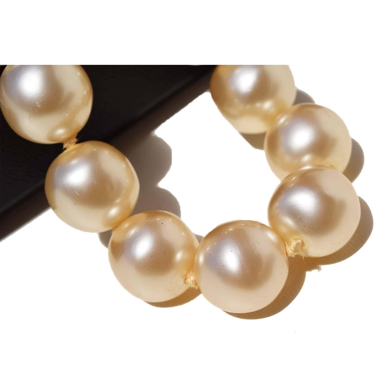 
Chanel vintage large faux pearl choker. Large ivory pearls strung with thick cotton thread. Goldtone harware. Small pearl with CC raised logo on hangtag. Collection 29 (1992), designed by Victoire de Castellane, who was hired by Lagerfeld to