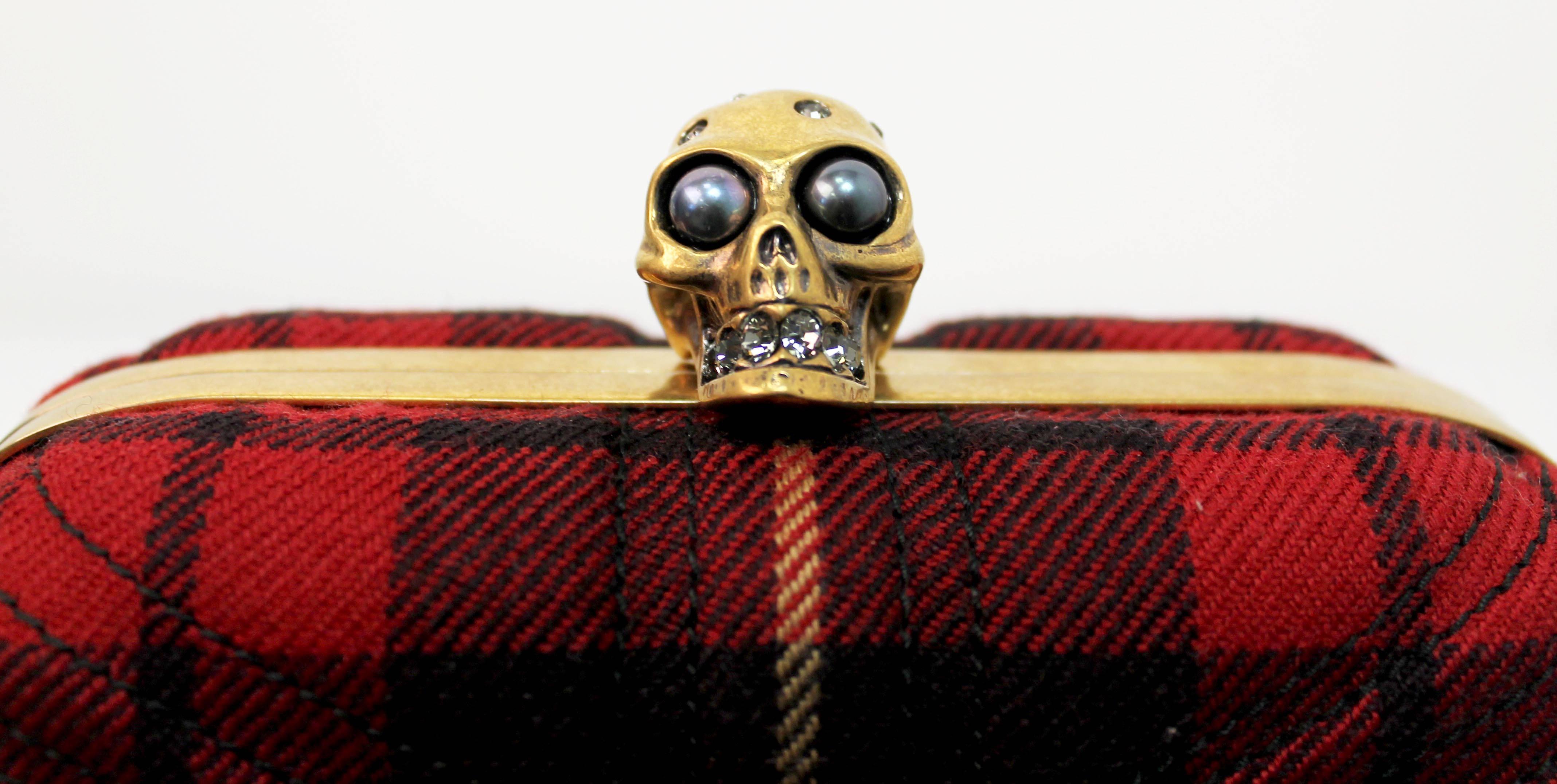 Iconic box clutch by Alexander McQueen. Features a top-stitched union jack on the exterior wool and a gold skull knob closure. Code is shown in image 6.