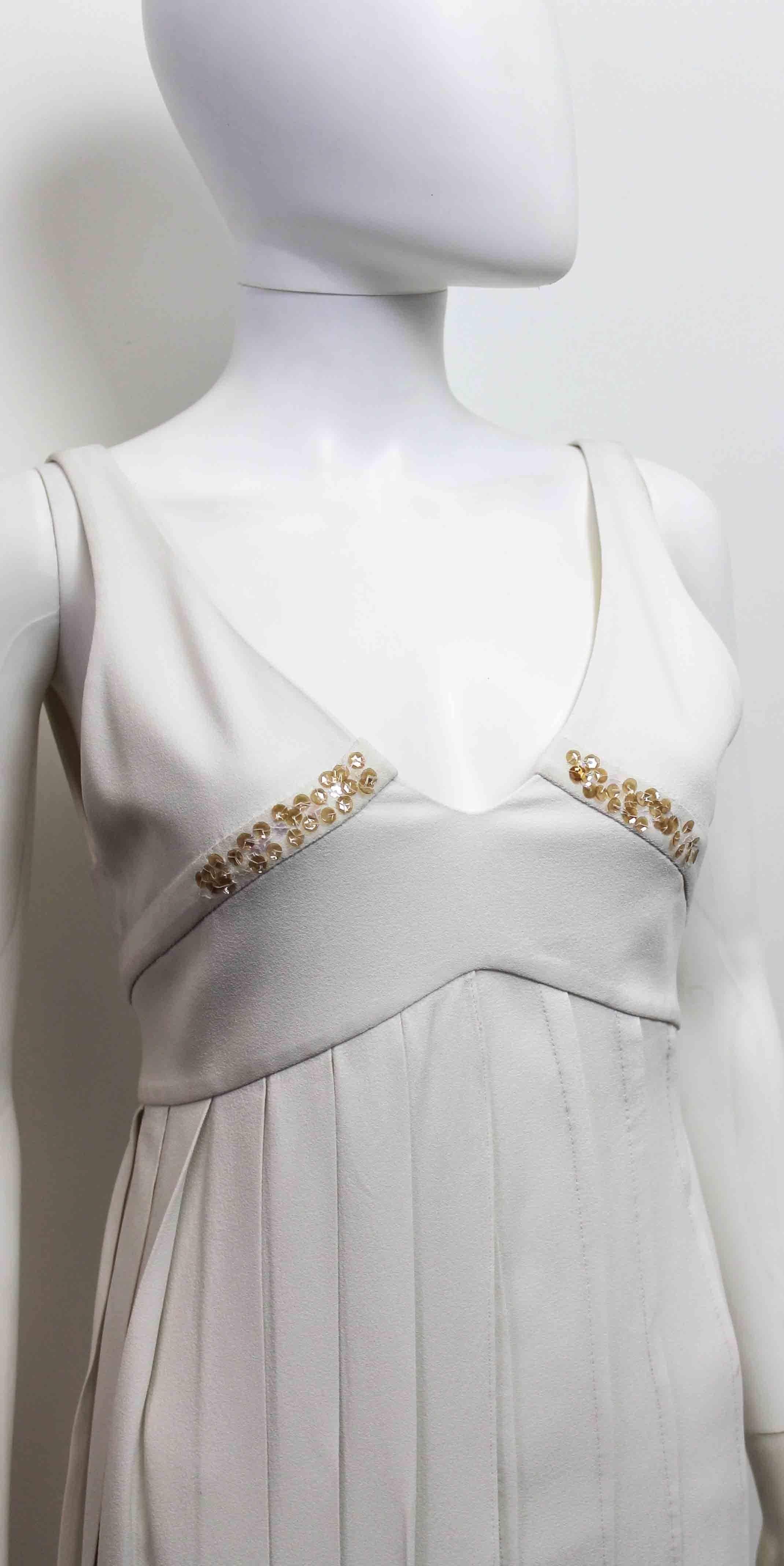 A beautiful piece by Christian Dior estimated to be from the mid 2000's. The dress features sequins along the bust line, a pleated front and a low back that ties in a bow. 