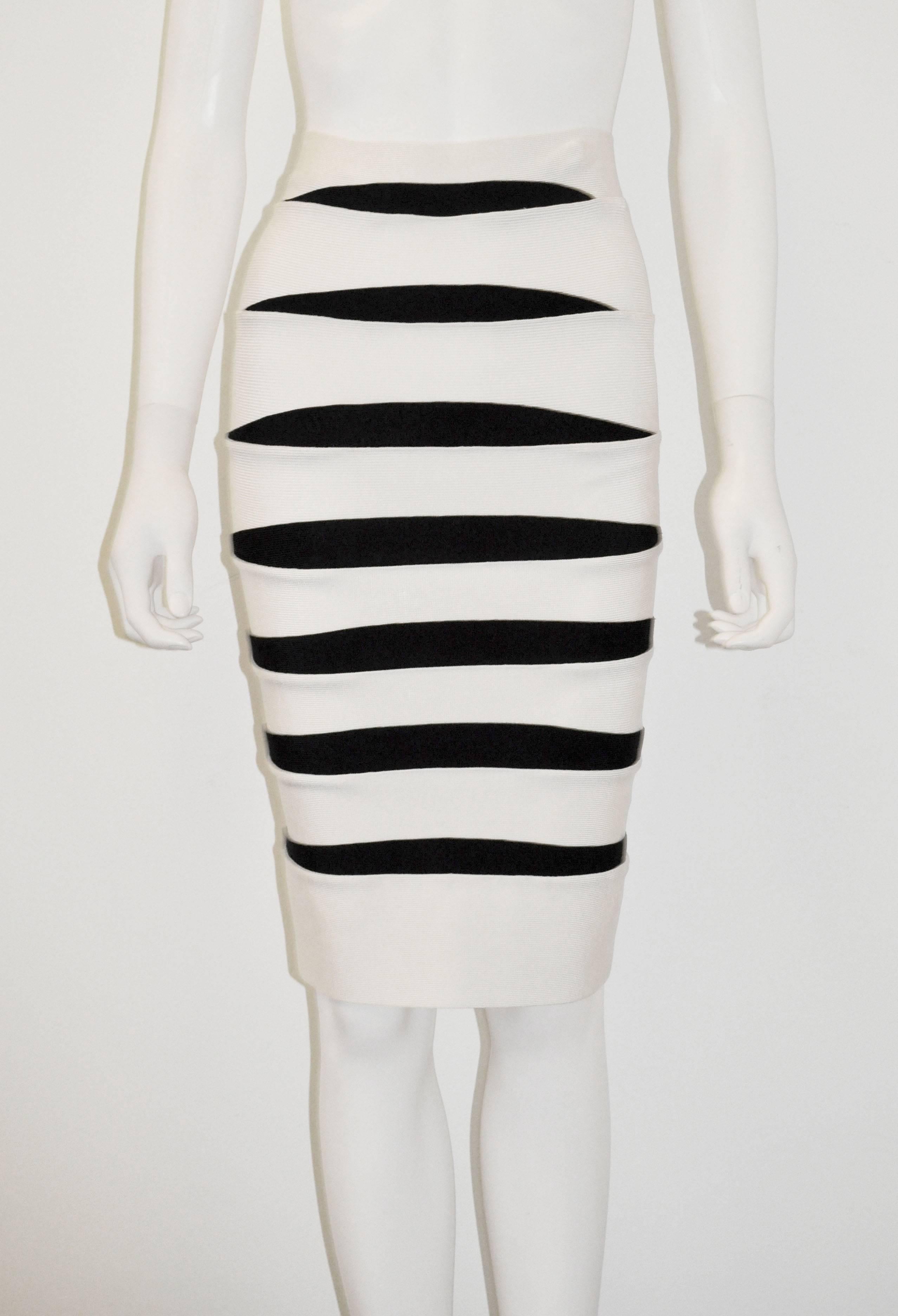 A stunning Herve Leger body con white bandage skirt with black horizontal contrast panels. The tight-fitting elasticated skirt is iconic to the Herve Leger brand. With a neutral colour palette of white and black, the skirt can be styled with almost