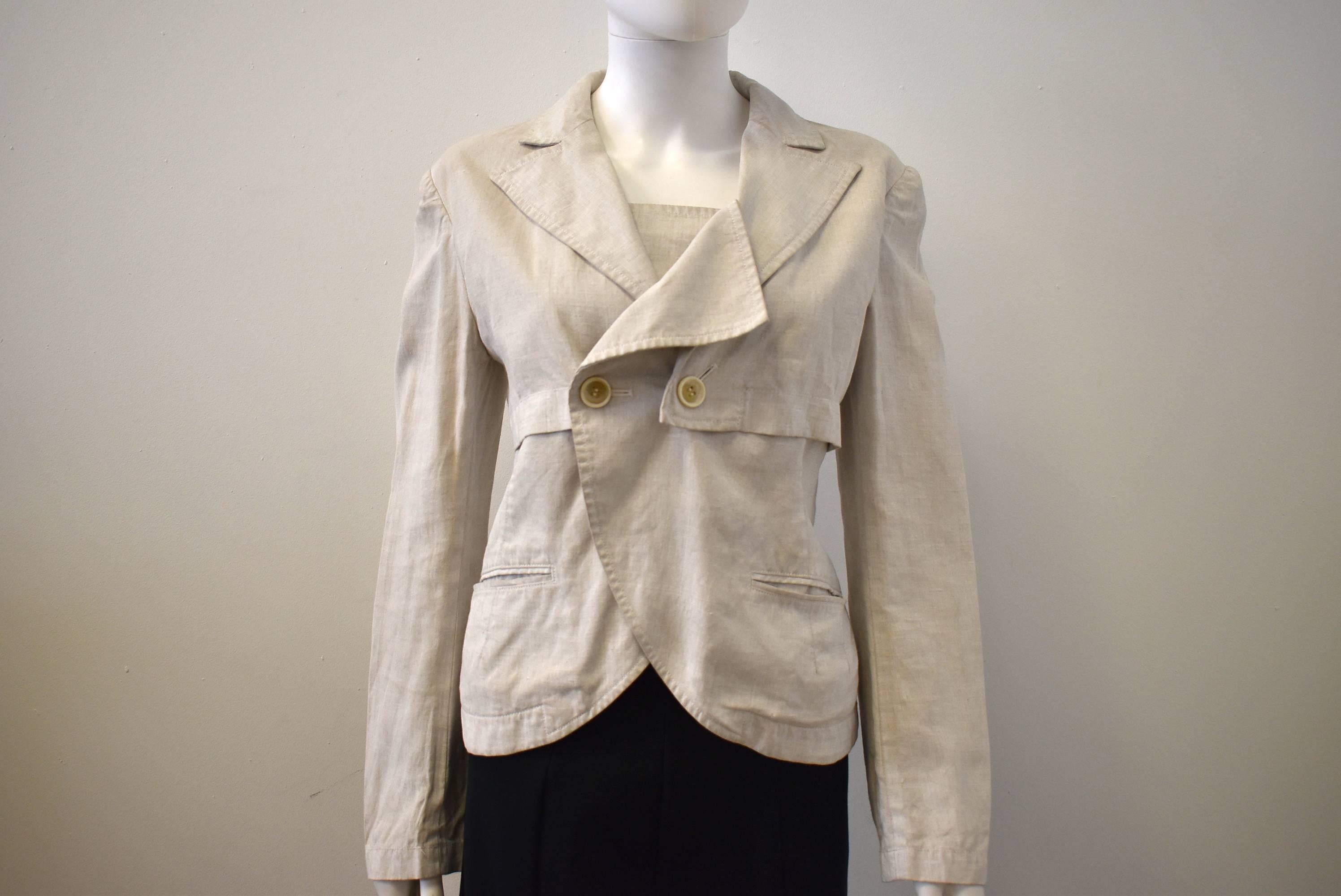 A contemporary off-white linen jacket from Yohji Yamamoto's Y's label. The jacket has a button fastening with the choice of two buttons in the centre of the jacket. It has an unusual folded collar and placket panel details as shown in the pictures.