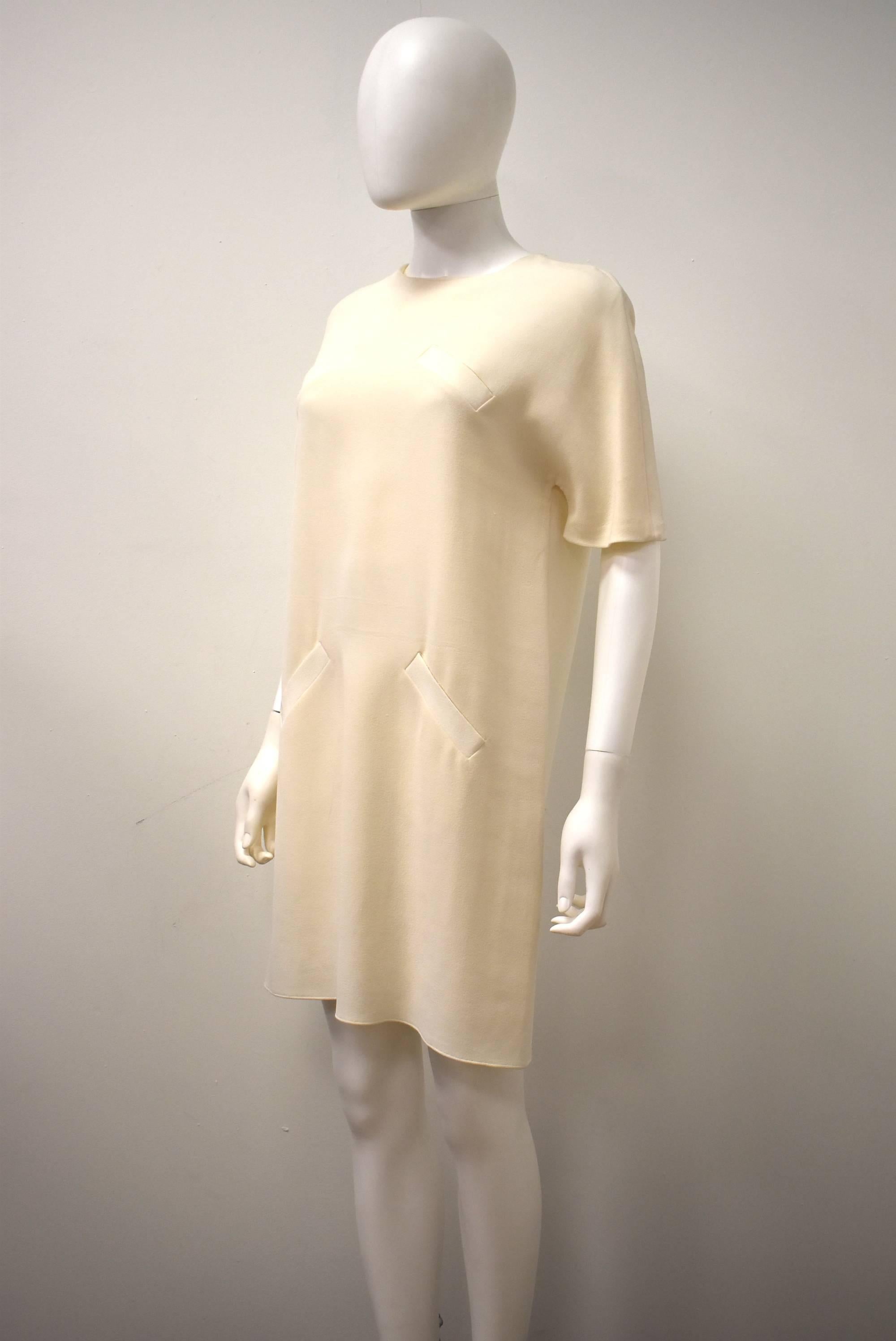 A beautiful and simple cream shift dress by Alexander Wang for Balenciaga from the …. collection. The dress is an elegant A-line shape, falling to just above the knees, with four pockets (two at the bust, and two at the hips) creating a modern twist