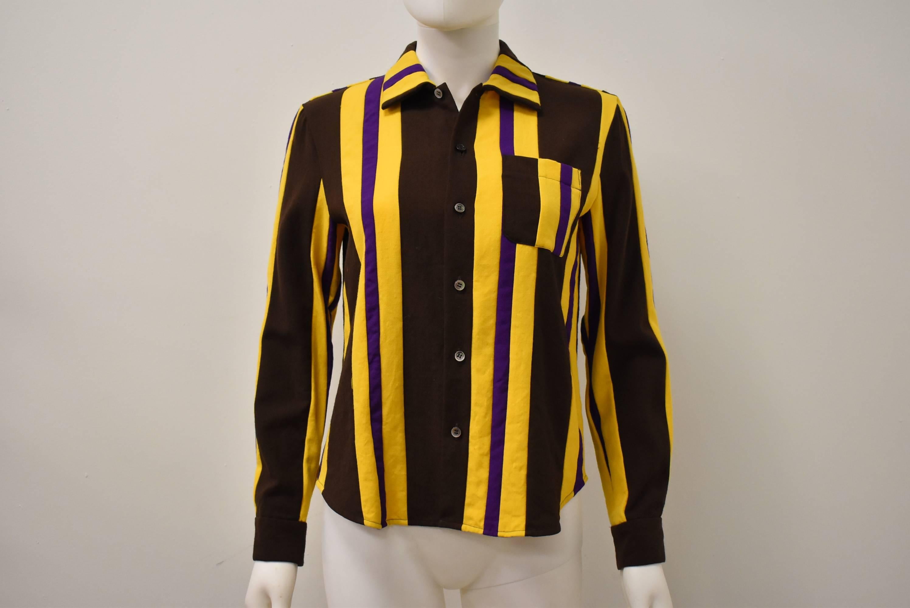 A bold coloured wool shirt from the Comme des Garcons Tricot label. The shirt is made from brown, yellow and purple vertical stripes of irregular widths creating a fun and graphic print.  The shirt has a simple shape with button down front, collars