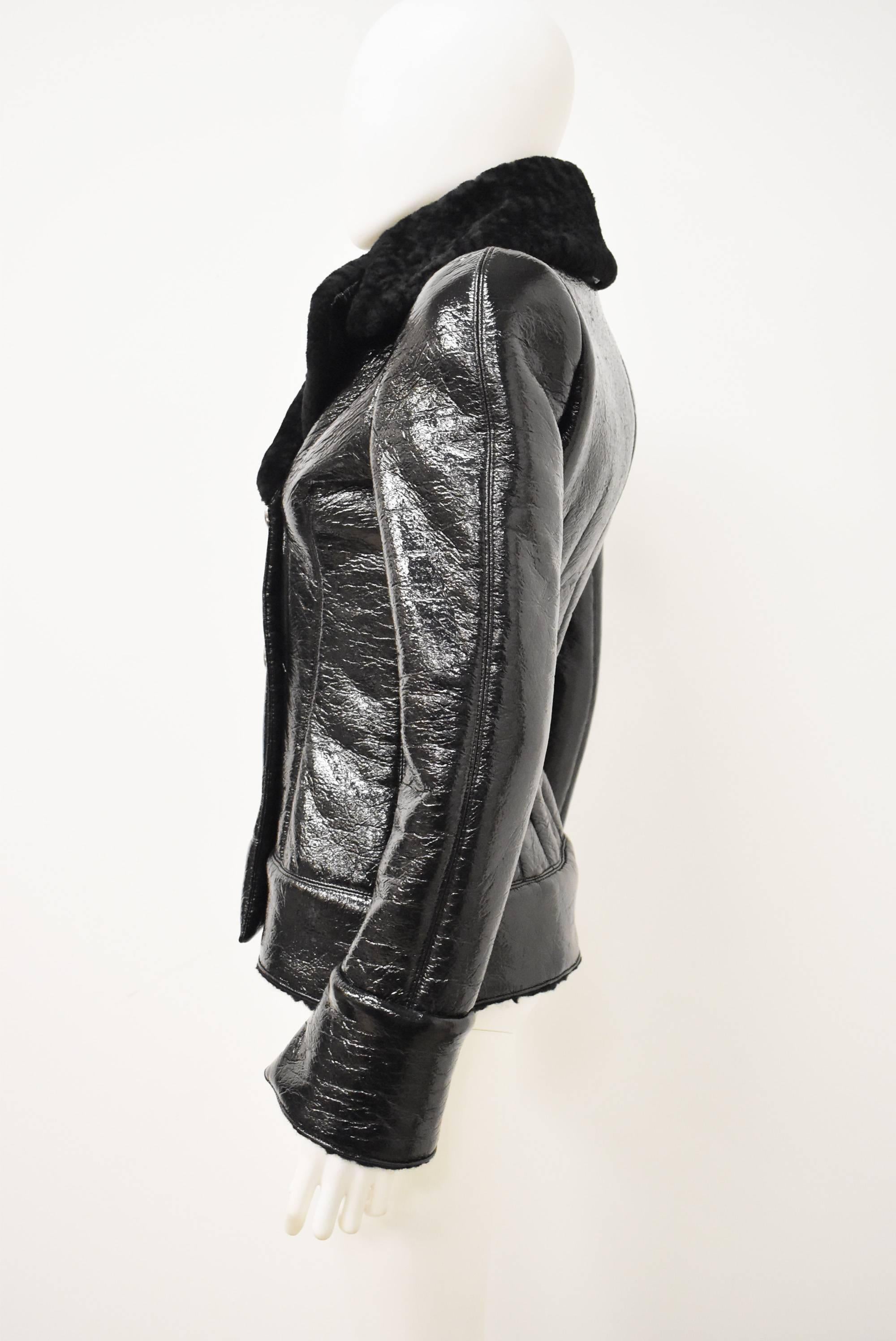 A luxurious patent leather and shearling jacket by Alexander McQueen. The jacket is double breasted with button fastenings at the front and oversize textured collar. The jacket has an extremely fitted shape with several darts in the back pulling in