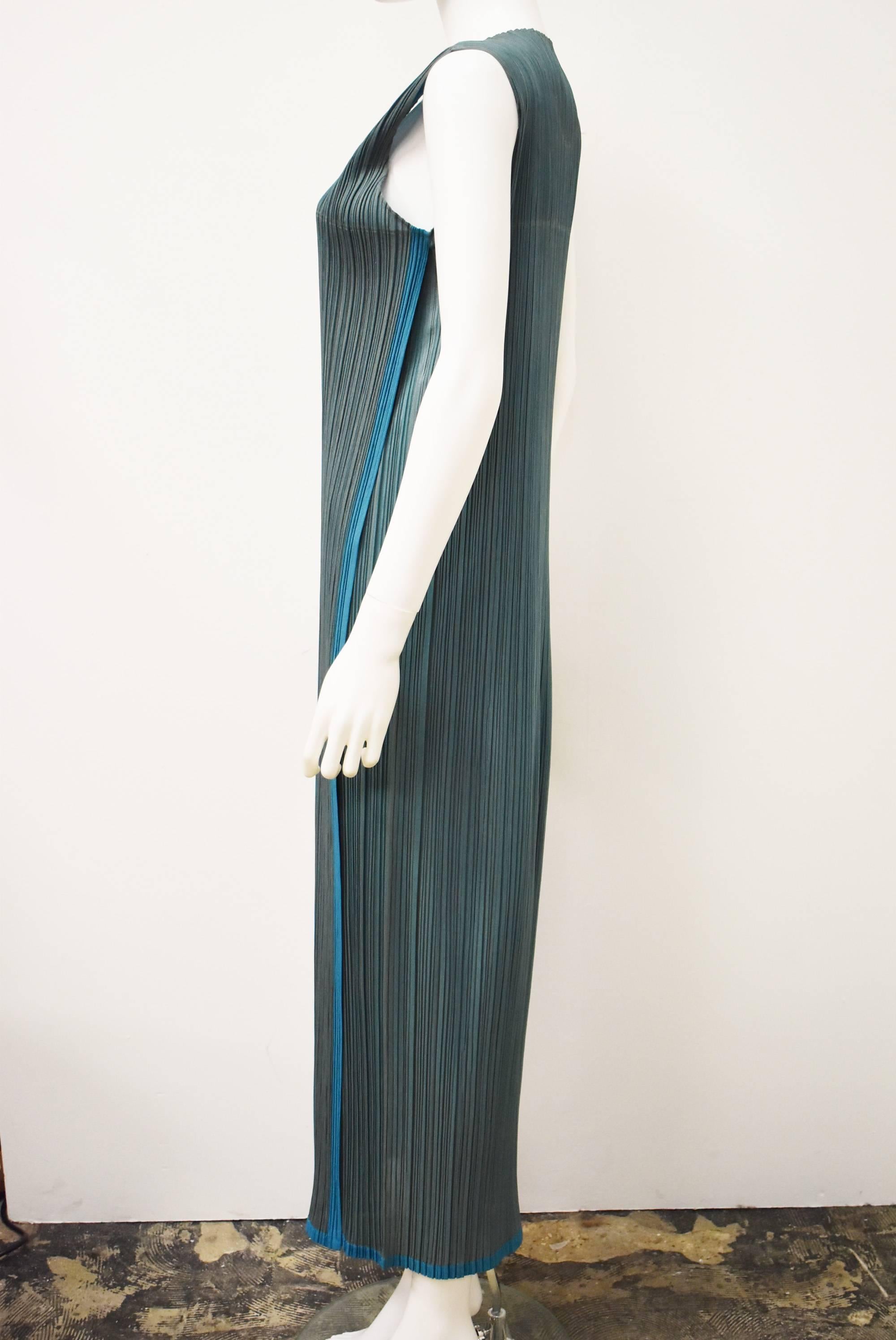 A two-tone turquoise accordion pleated dress from Issey Miyake's synonymous line Pleats Please. The dress has a simple shift shape, adapting to the shape and movements of the wearer. The dress has an unusual two-tone colour creating a striking