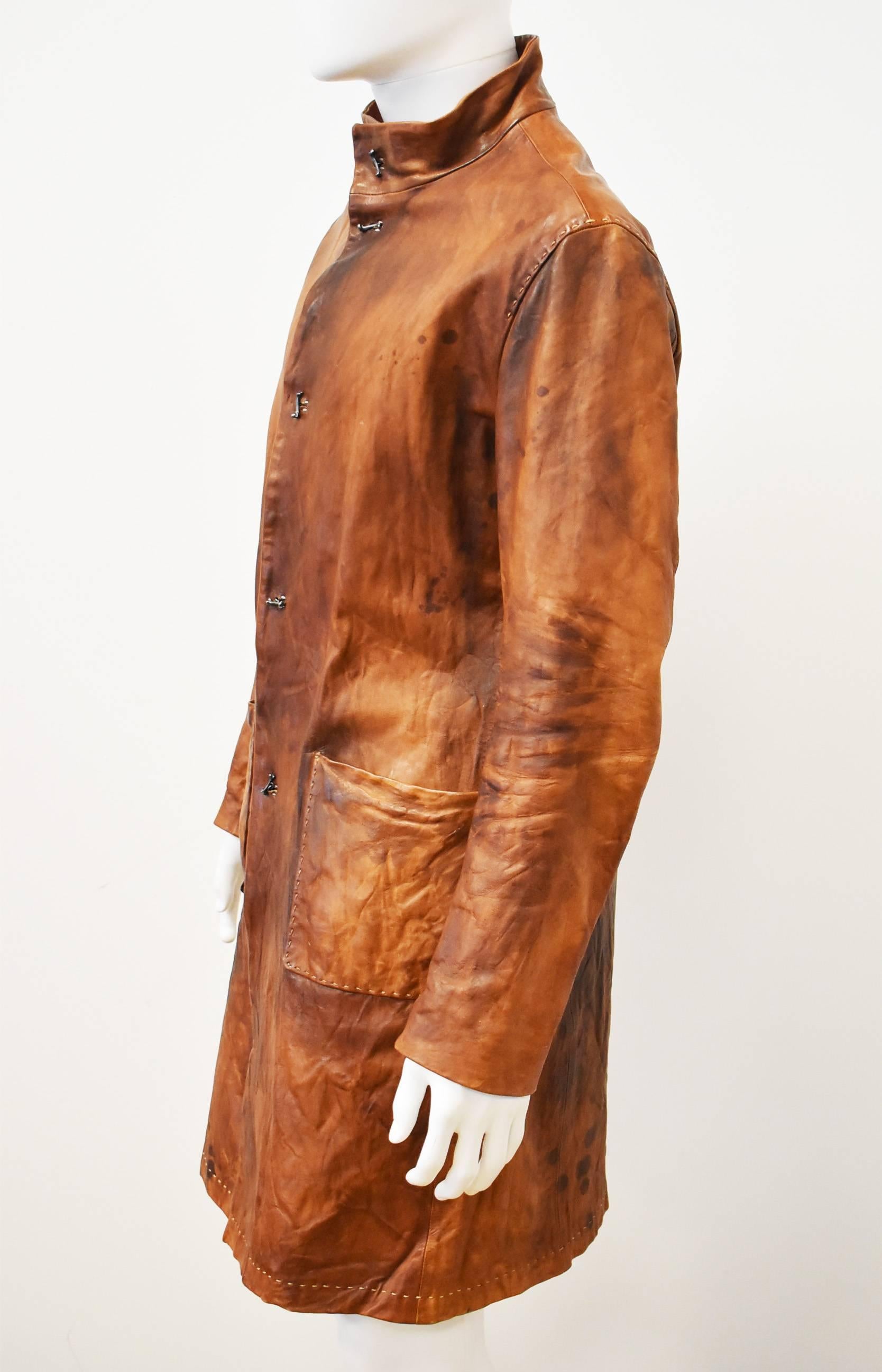 This beautiful and unique coat is made by Japanese leather artist Hideo Motoike. The artist is known for making sculptures, art, clothing and shoes entirely from leather. The coat is made from tan coloured ’distressed’ leather, with a deliberately