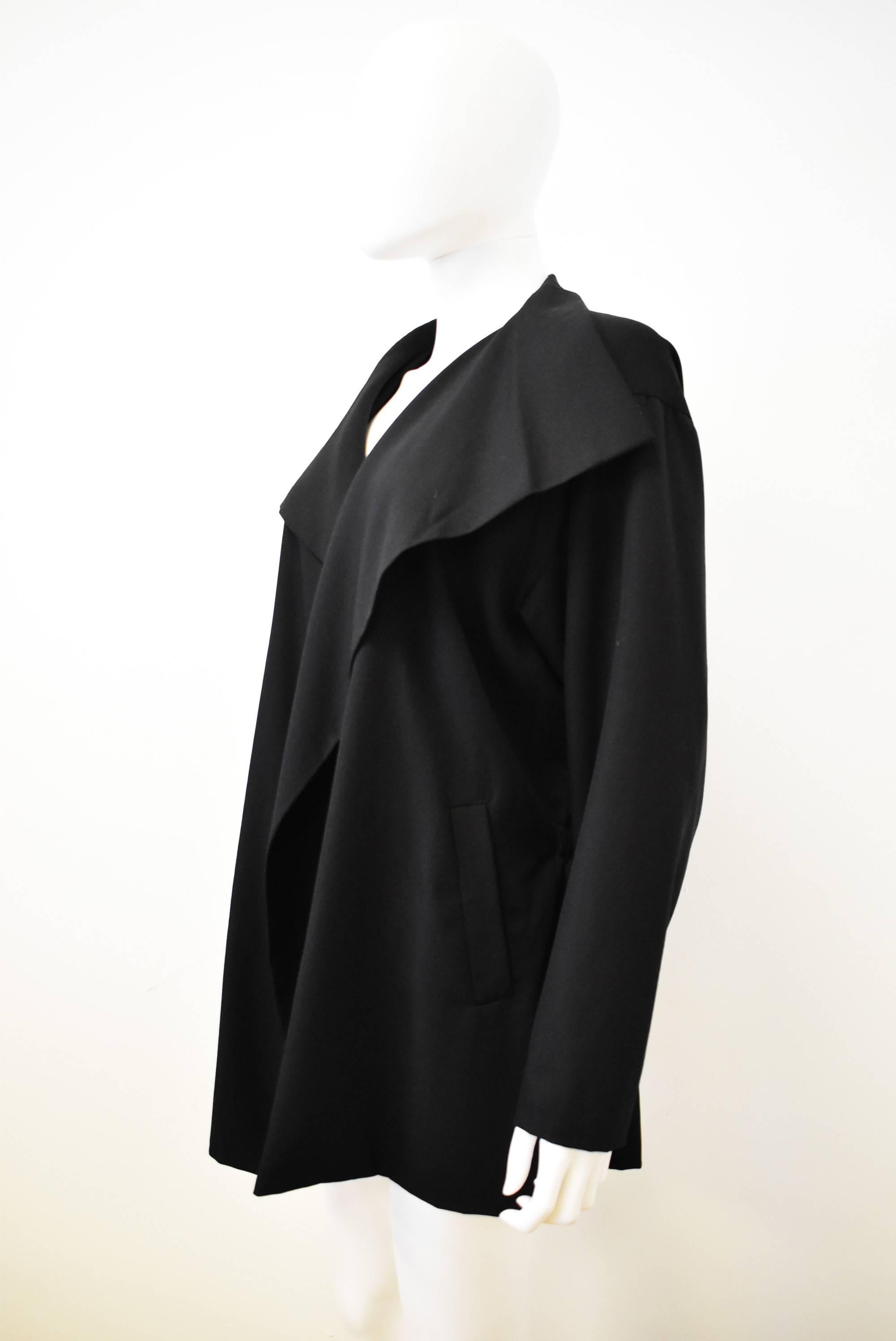 This Plantation by Issey Miyake jacket dates from the 1980s, with an open front and an oversize collar that drapes on either side. The jacket has an elasticated waistband at the back creating a fitted shape at the back that contrasts the drapery at