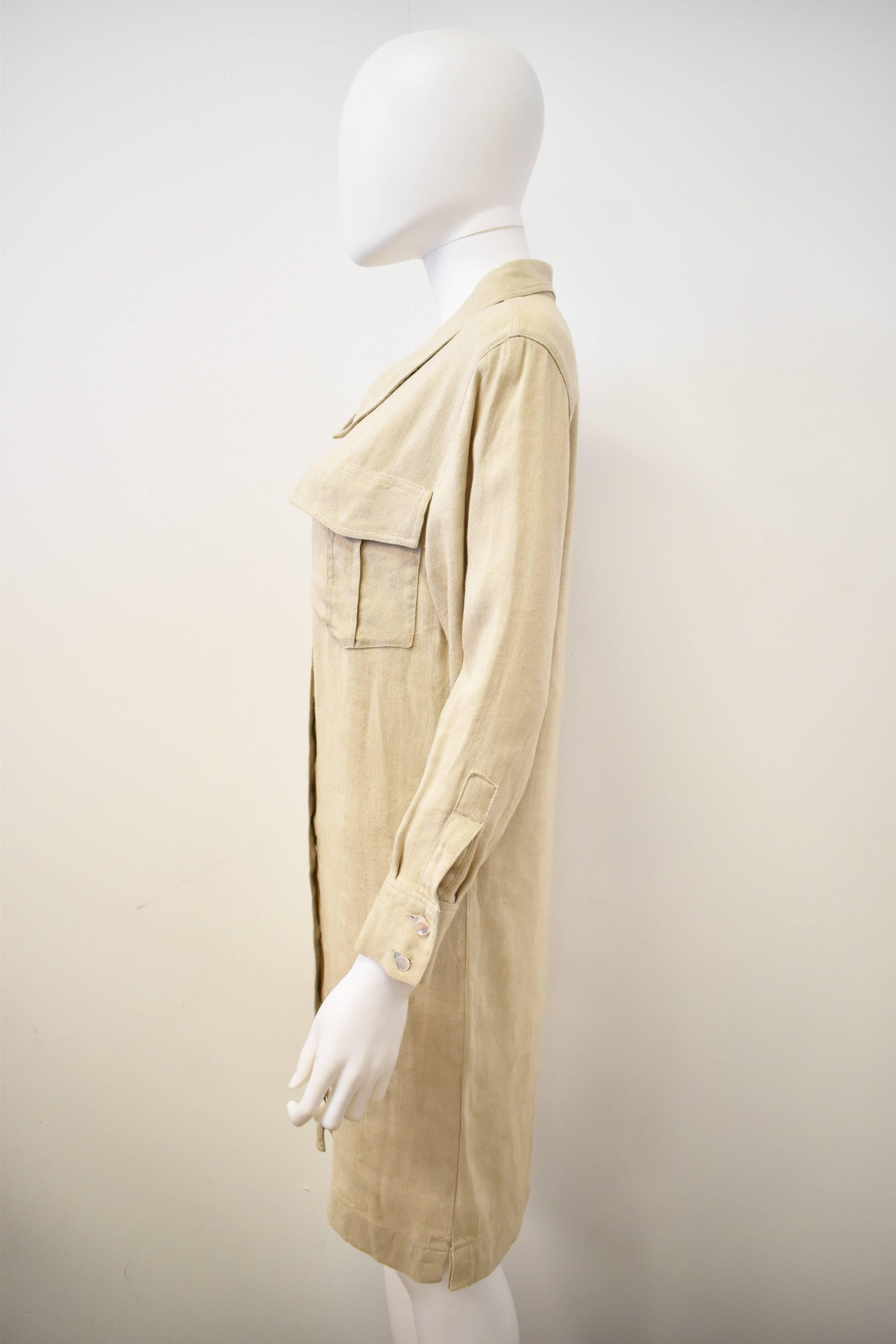 A classic and Summery beige linen and silk blend shirt dress from Chanel’s Boutique line. The shirt has a straight long line shape with a button up front, large collar and cuffs. The material has a light texture with the slight roughness of linen.