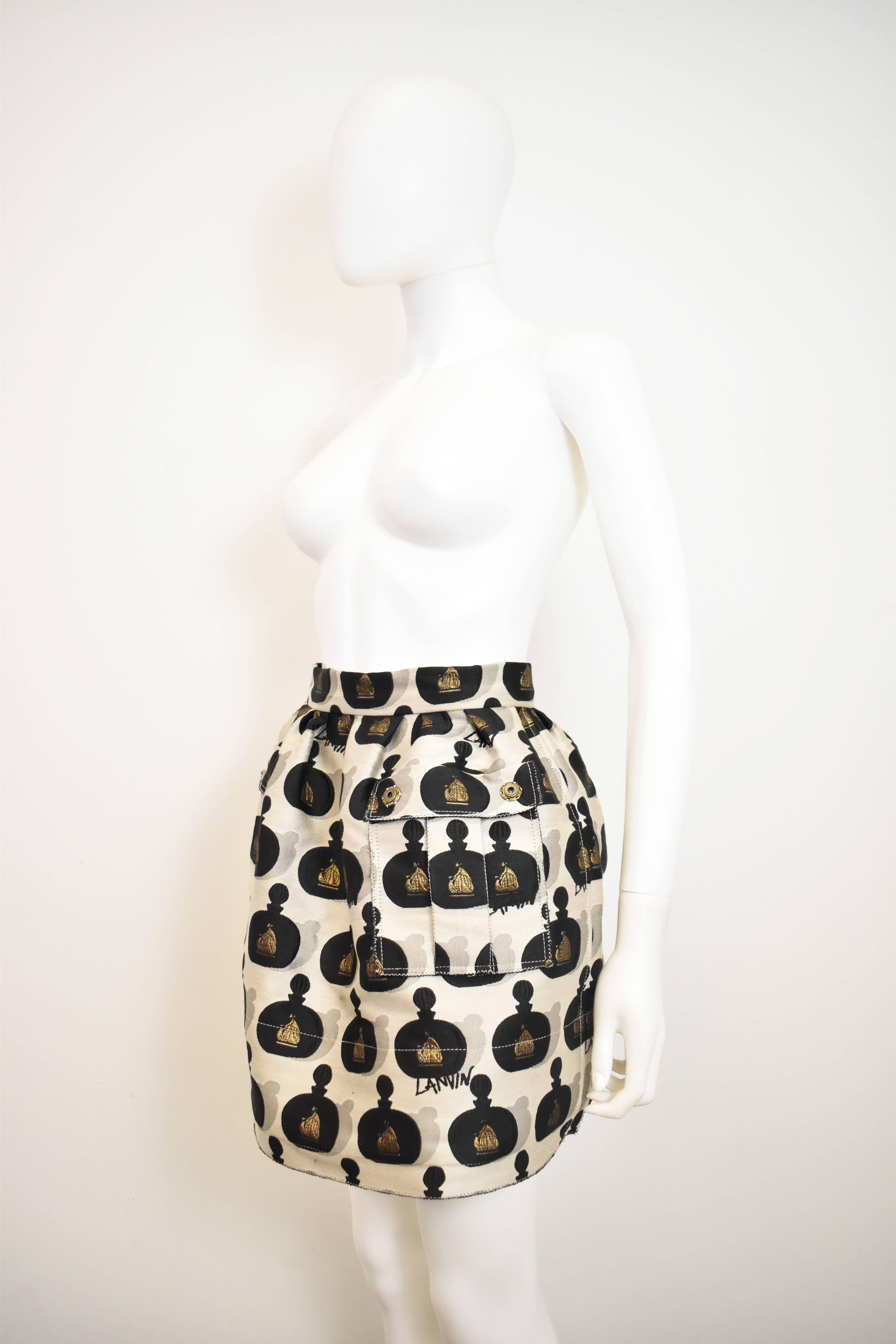 A brand new and unworn Spring/Summer 2016 Lanvin puff-ball skirt. It is made from a champagne and black coloured brocade fabric with perfume bottle design and gold thread Lanvin logo. There is also a repeated ‘Lanvin’ graffiti style text throughout