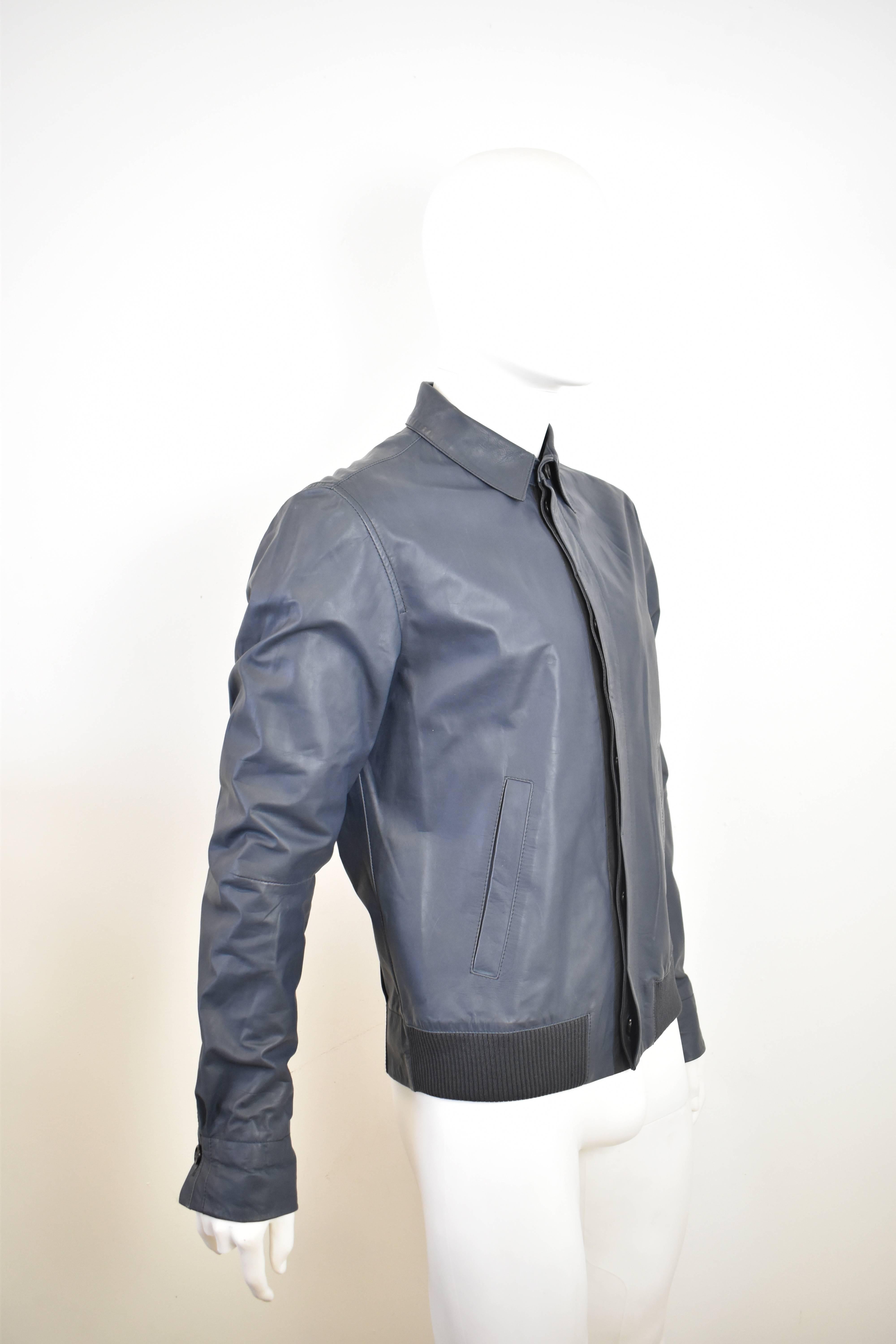 A blue men’s zip-up leather blouson jacket from Alexander McQueen. The jacket has a slim fit, with a shirt-like design that has been mixed with a bomber jacket creating a perfect transitional season light jacket/blouson. It is made from 100% leather