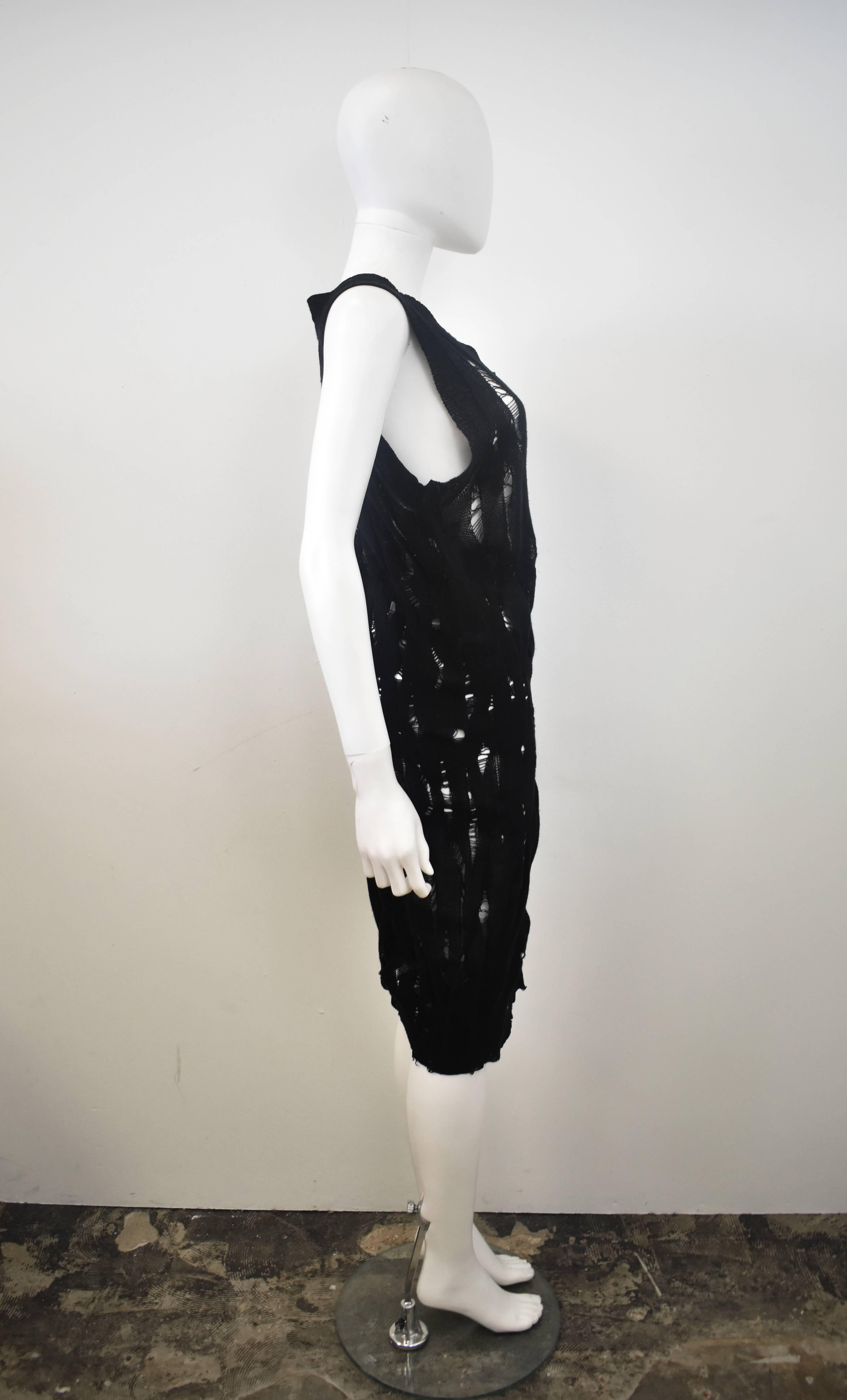 A distressed black Junya Watanabe knitted dress from 2009. This dress has a simple sleeveless shape with a slightly asymmetric hemline. The dress is made from 100% wool that has been purposely ripped and laddered all over to create a distressed