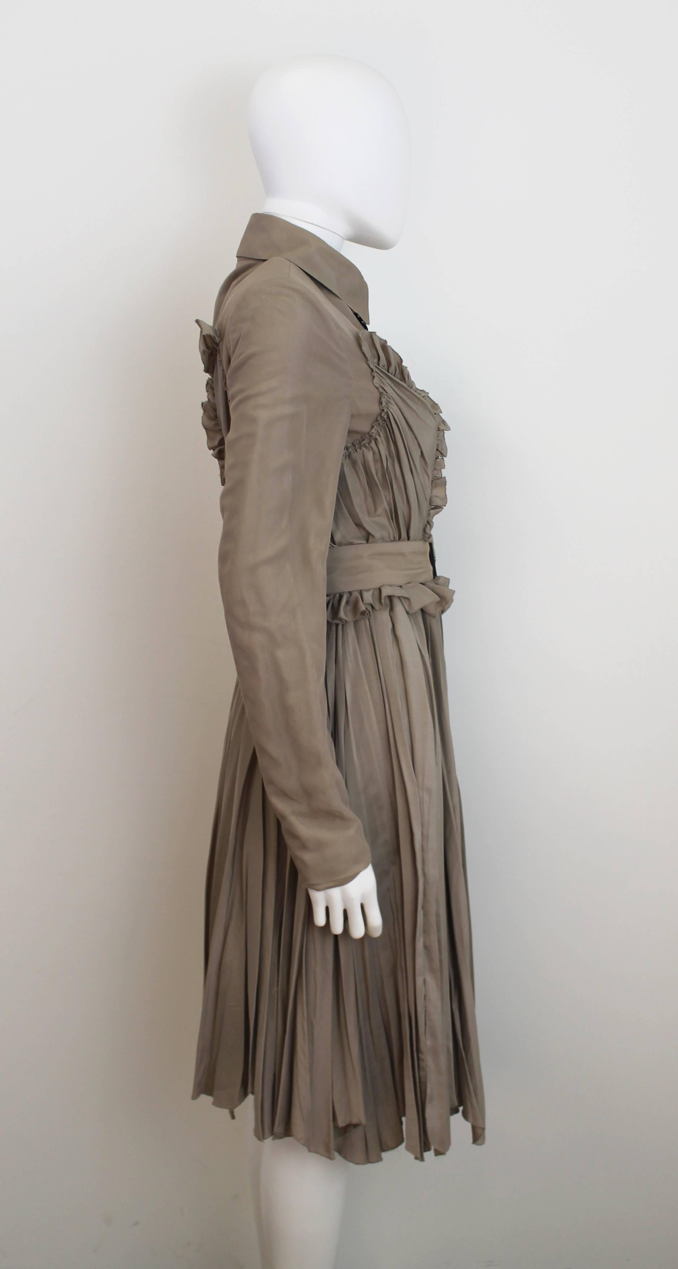 A double-breasted Burberry Prorsum trench in the style of a dress, with pleated and ruched detailing on the skirt juxtaposed with an overlay of silk tulle along the sleeves and neck. From Resort 2010 collection.
A modern take on the classic