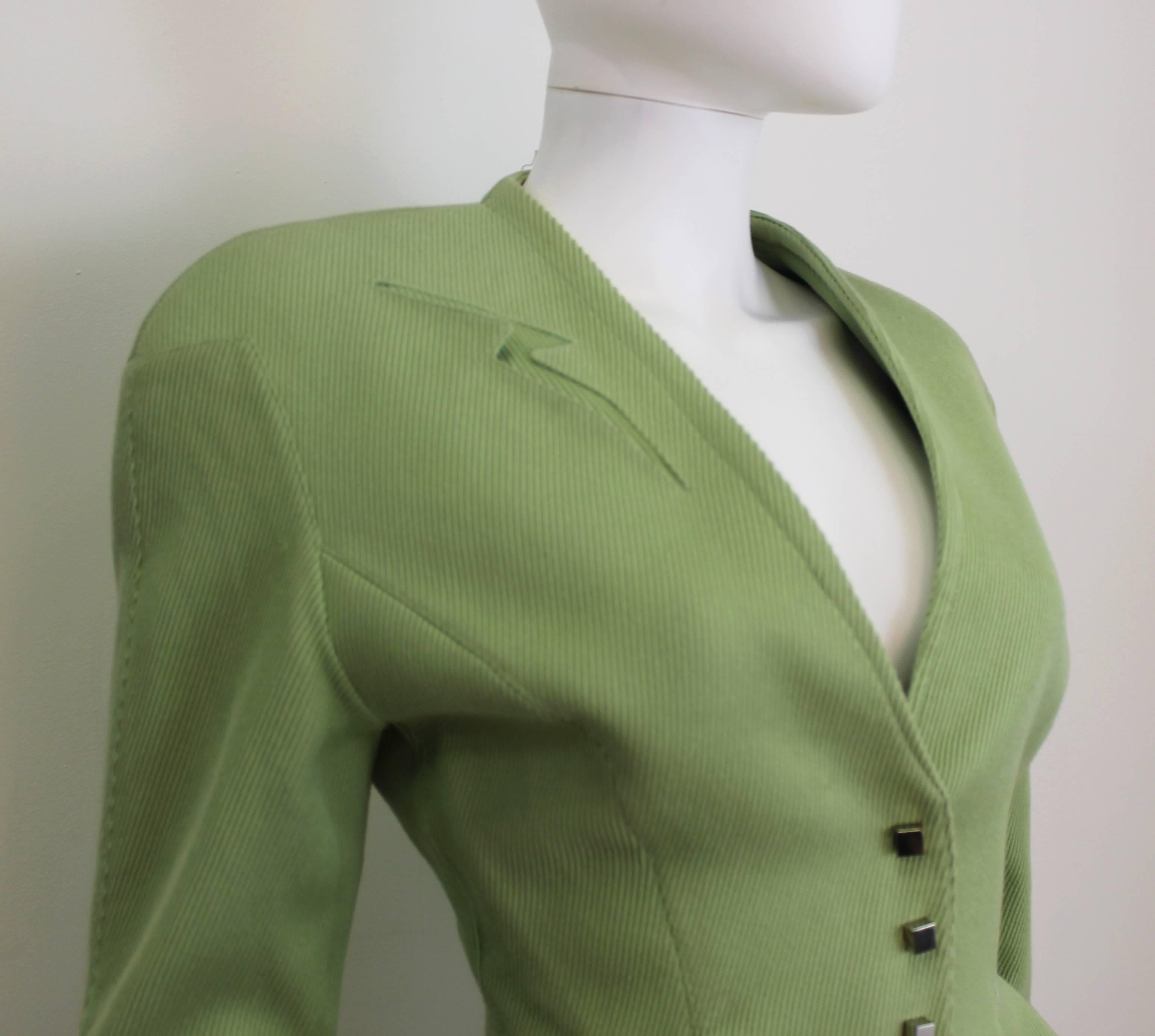 Iconic Thierry Mugler light green jacket from the 1990's. Features cut-out lightening bolt detail pocket on upper right chest and a flared peplum.