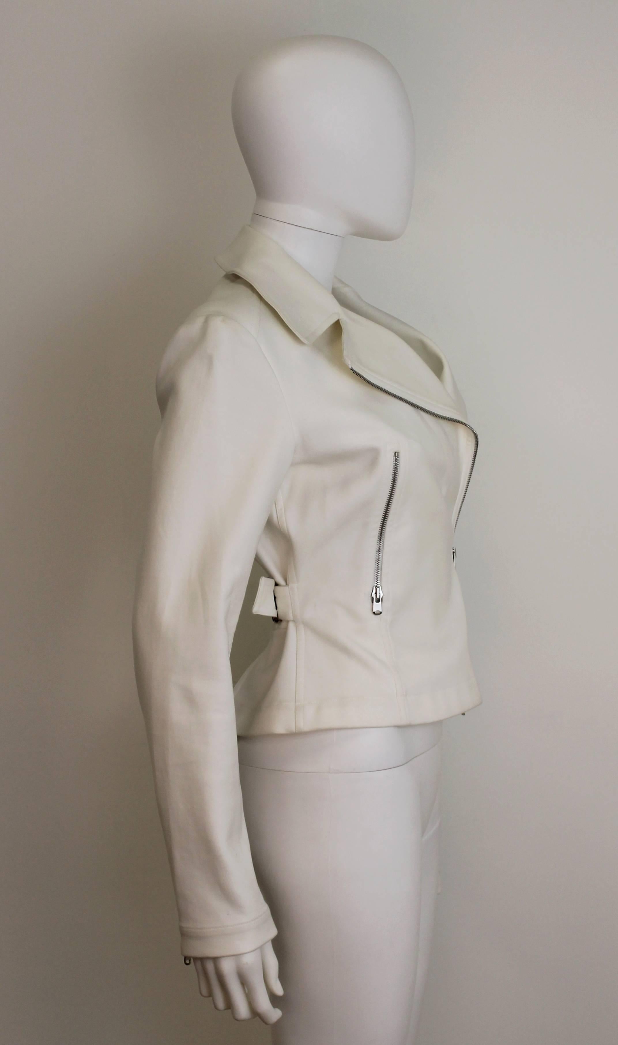 Classic white Alaia motorcycle jacket in stretchy cotton. Features silver zip closure and adjustable buckle waist.