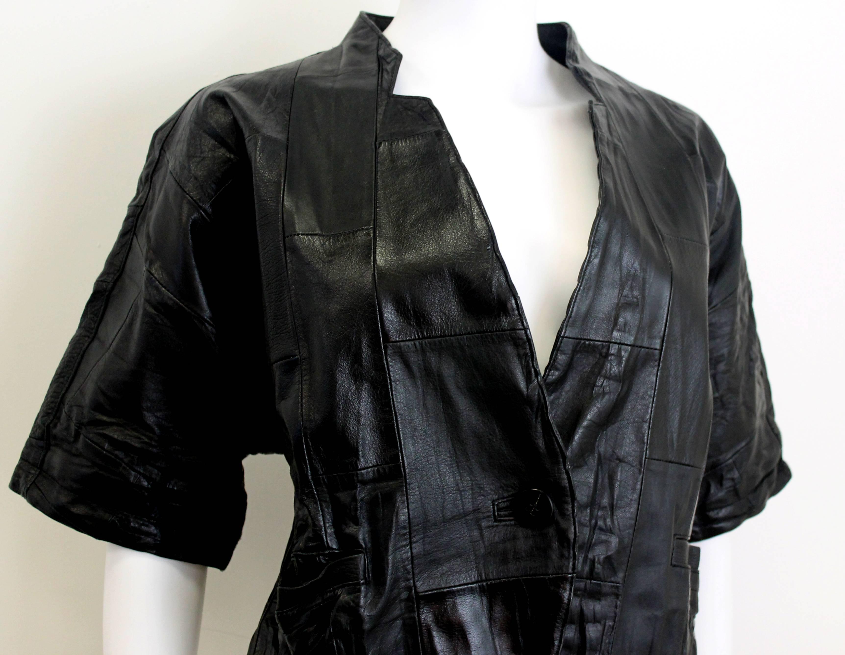 Issey Miyake black leather jacket with patchwork jacket. Features single button closure and an open neckline.