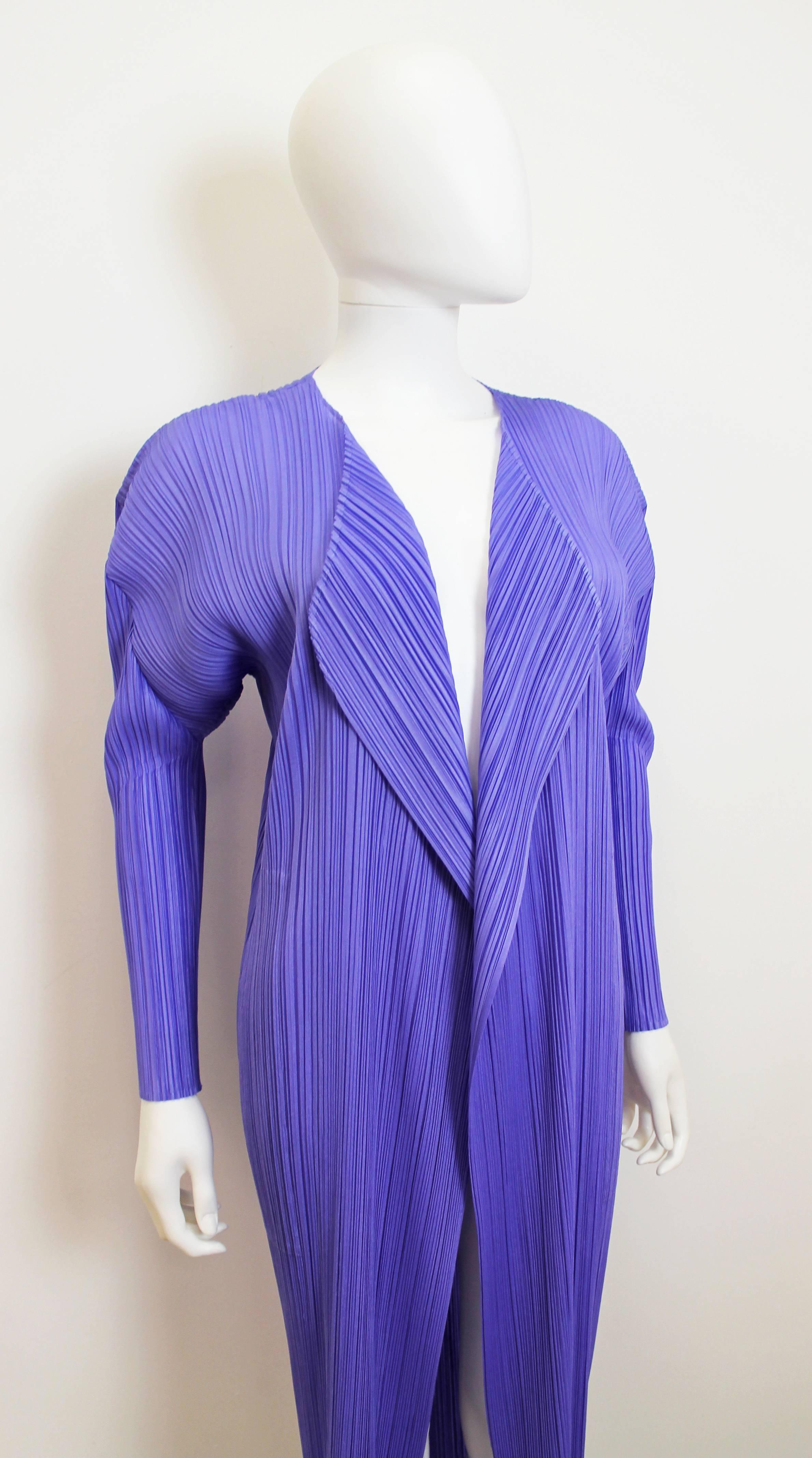Classic Issey Miyake Pleats Please pleated coat in periwinkle. Believed to be from the late 90's. Features two pockets hidden in the side-seams, as well as a collar that can be flipped up or down. Can fit many sizes.