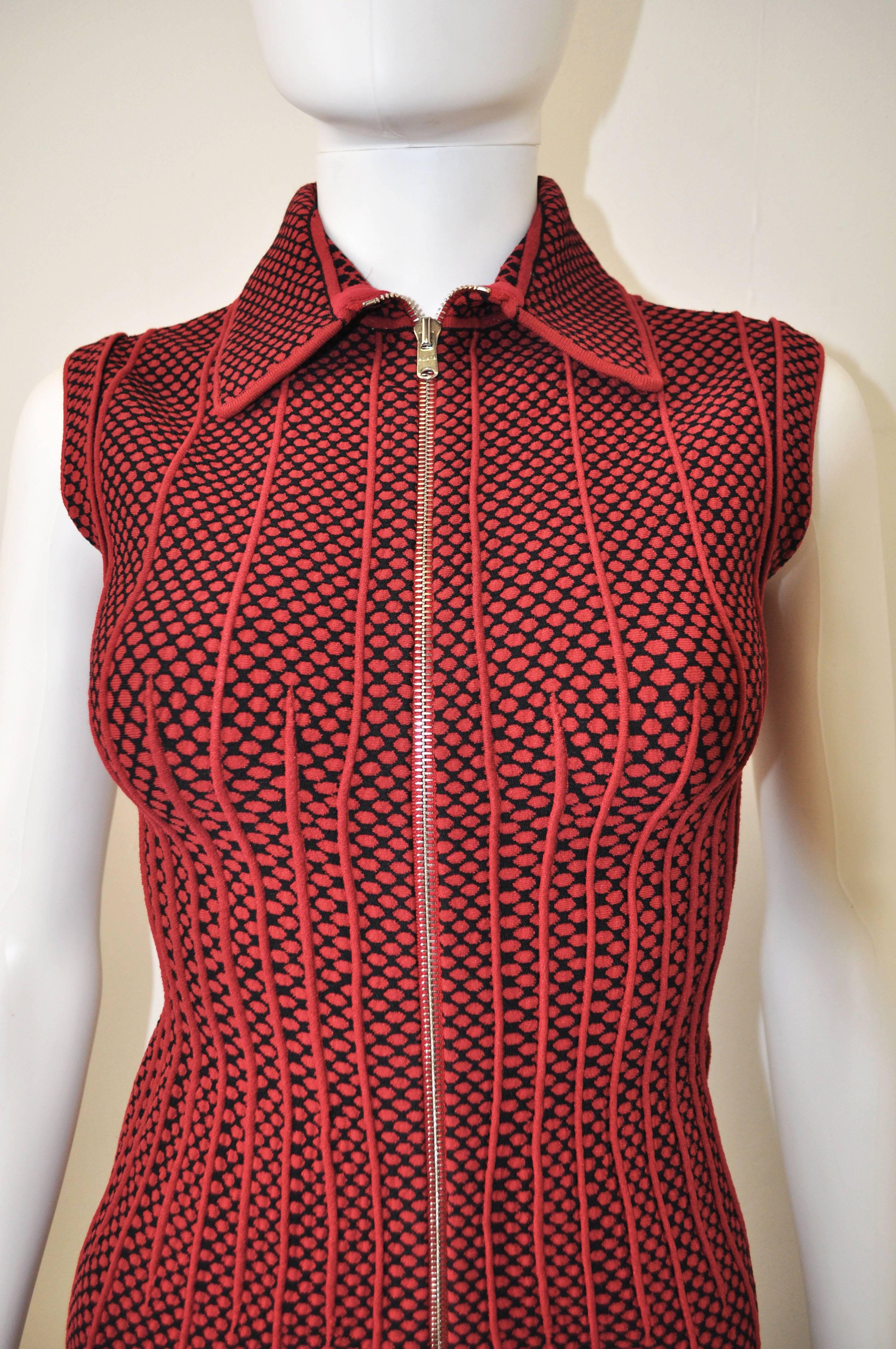 This is a very figure hugging Azzedine Alaia zip front sleeveless dress with collar. This red and black polka dot pattern dress is decorated with red piping details to accentuate the waist and length of the dress. The dress is made from Alaïa’s