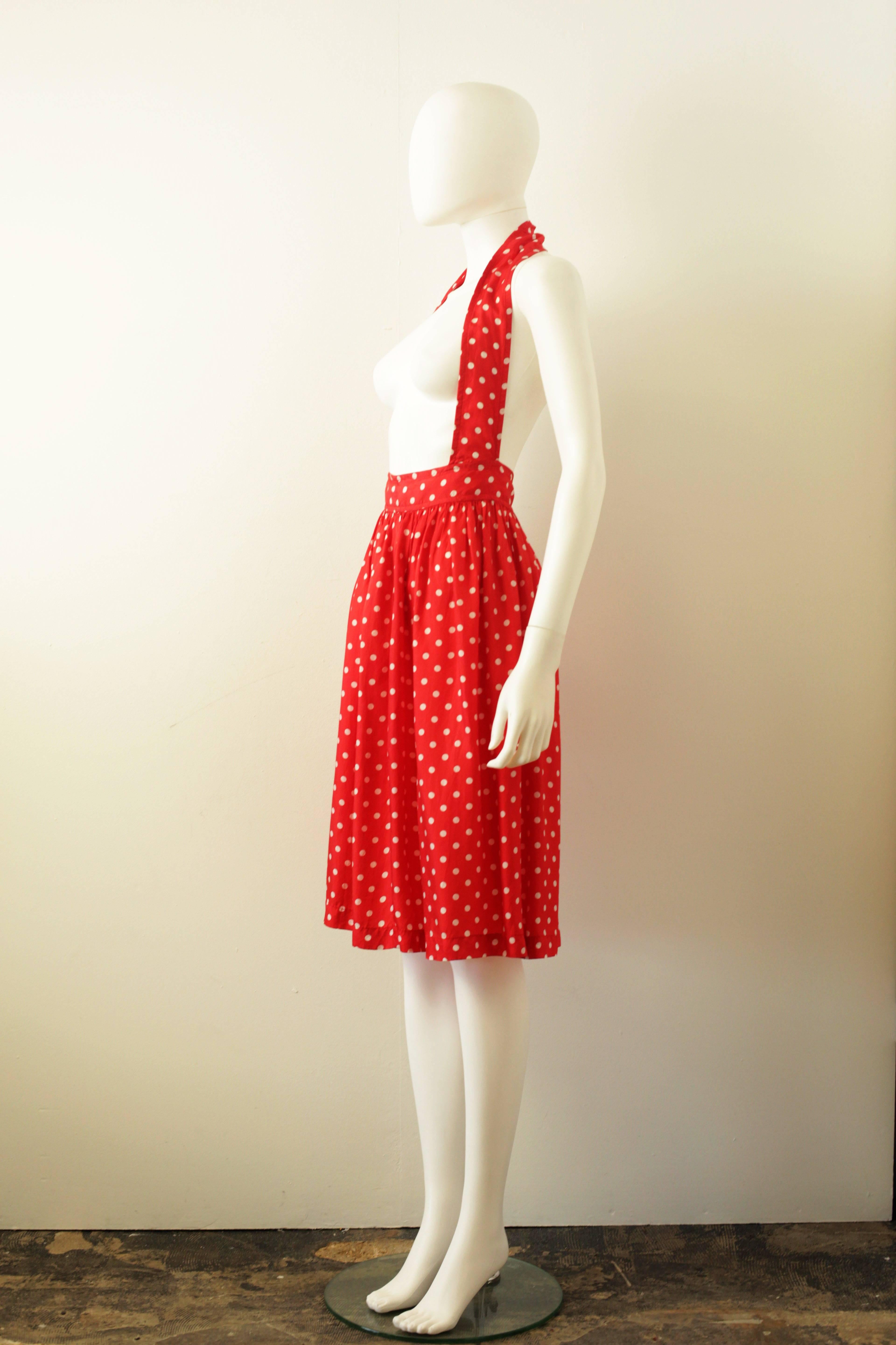 This is a beautiful red and white polka dot silky skirt with diagonal shoulder harness from Comme des Garcons. The skirt shape is a classic from CDG, oversize waist, shoulder brace and softly ruched at the waist to create soft folds in the