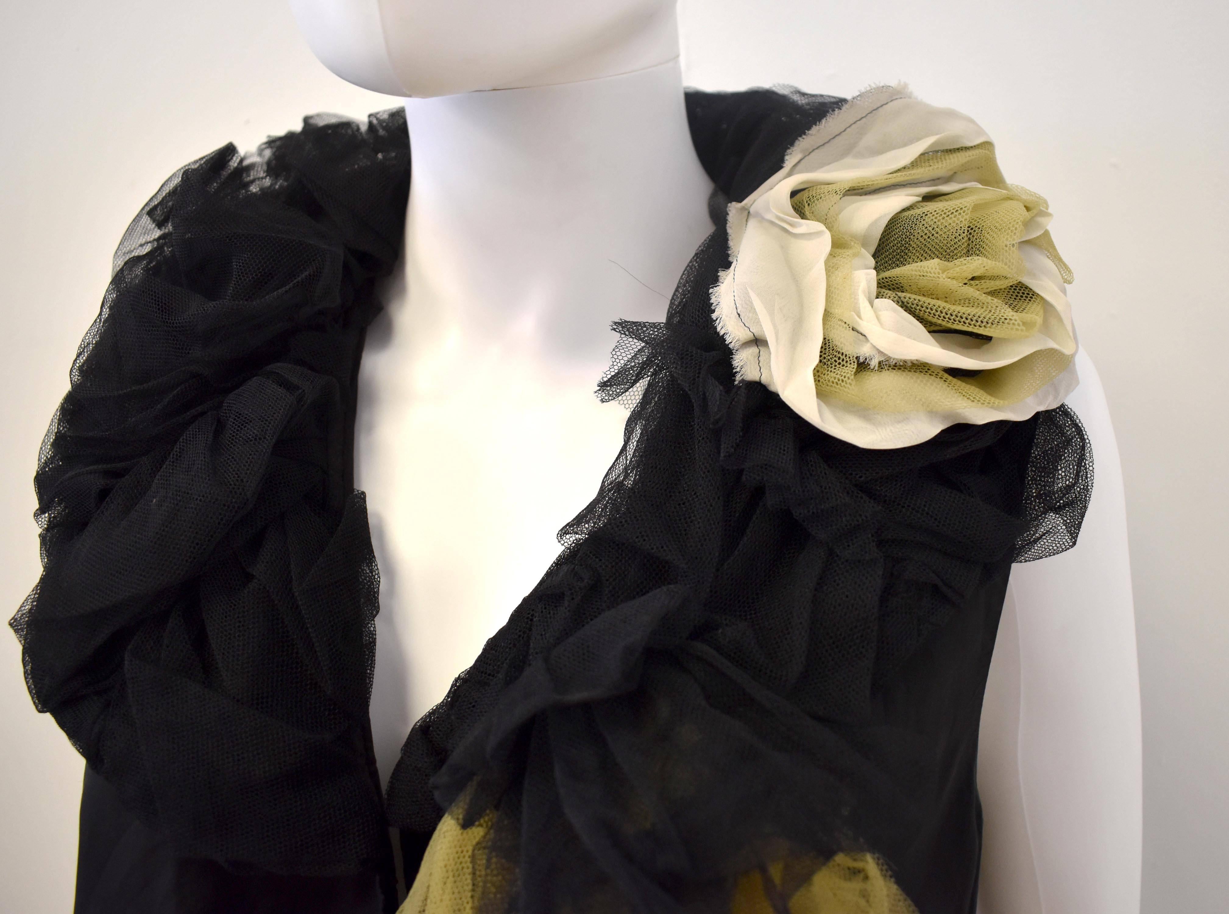 A unique black silky vest with ruffled tulle collar detail from the Robe de Chambre line of Comme des Garcons. The collar uses a mix of black, green  and beige tulle to create decorative and textured roses. The vest is a unique piece that can be