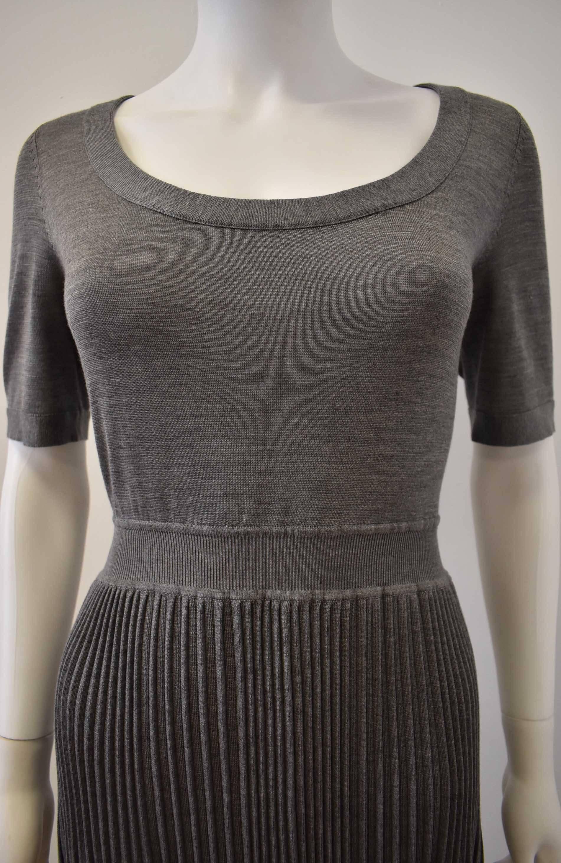 A beautiful and luxurious light grey silk and cashmere knitted dress with French fashion house Balenciaga. The dress has a scoop neckline, short sleeves and a classic skater skirt shape with fitted, stretch-knit waist and a flared and pleated skirt.
