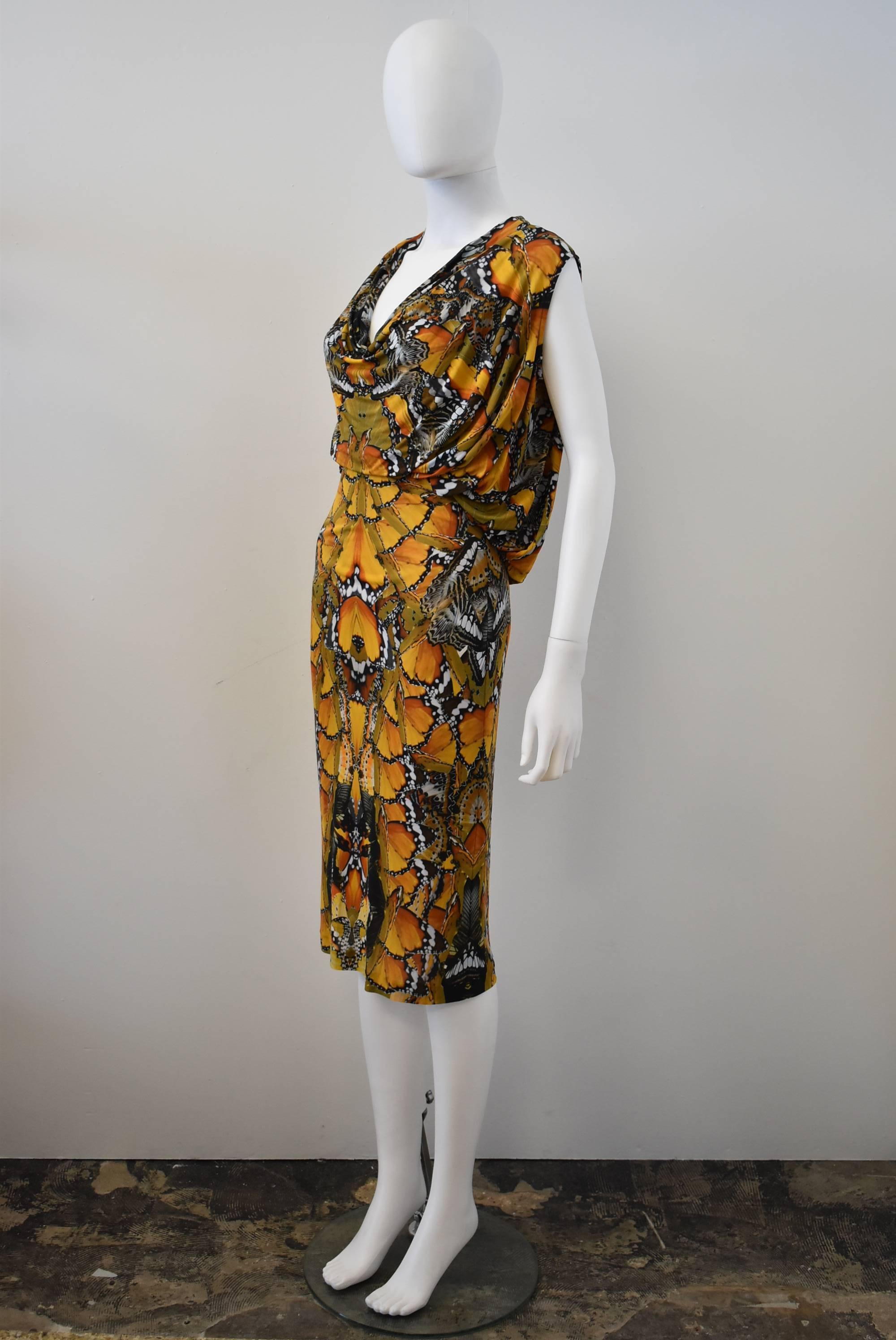 An elegant and beautiful yellow and black abstracted butterfly digital print dress from Alexander McQueen. The dress is made from a stretch viscose material that clings to the body creating an elegant silhouette. The dress has cowl-like drapery at