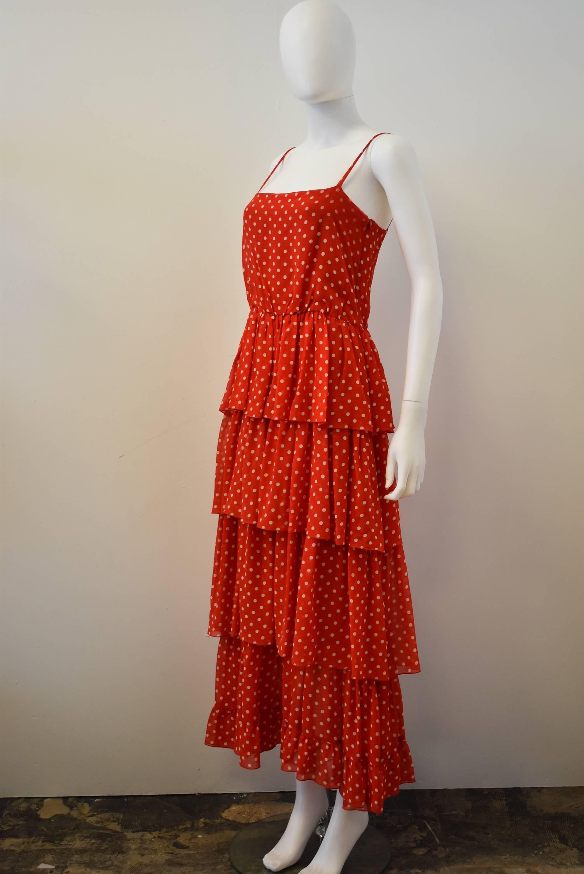 This Guy Laroche dress dates back to the 1970s. The dress is made from a red and white polka dot printed silk chiffon fabric. The dress is cut in tiered ruffles very reminiscent of the peasant style of the 70s. The dress also has spaghetti straps,